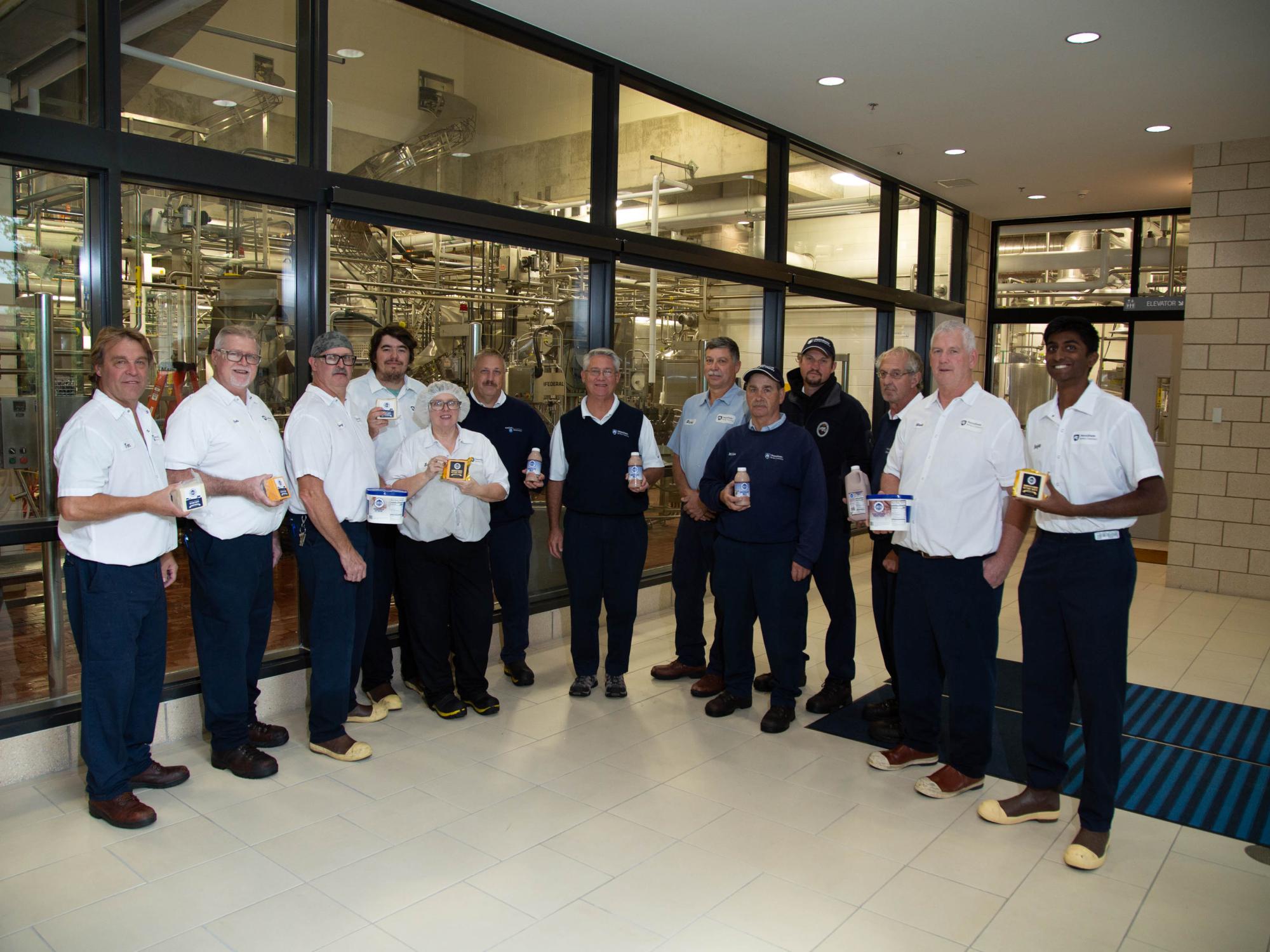 A large group of reamery staff line up and look at the camera