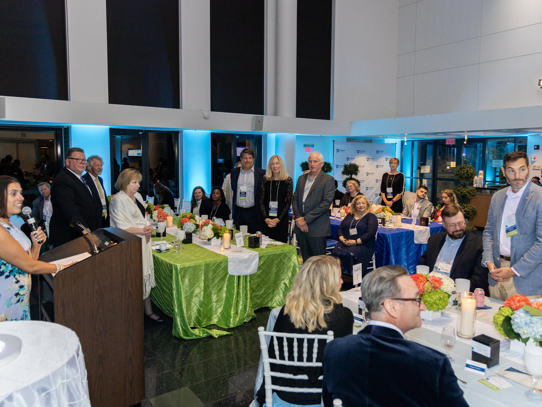 People sitting and standing at tables