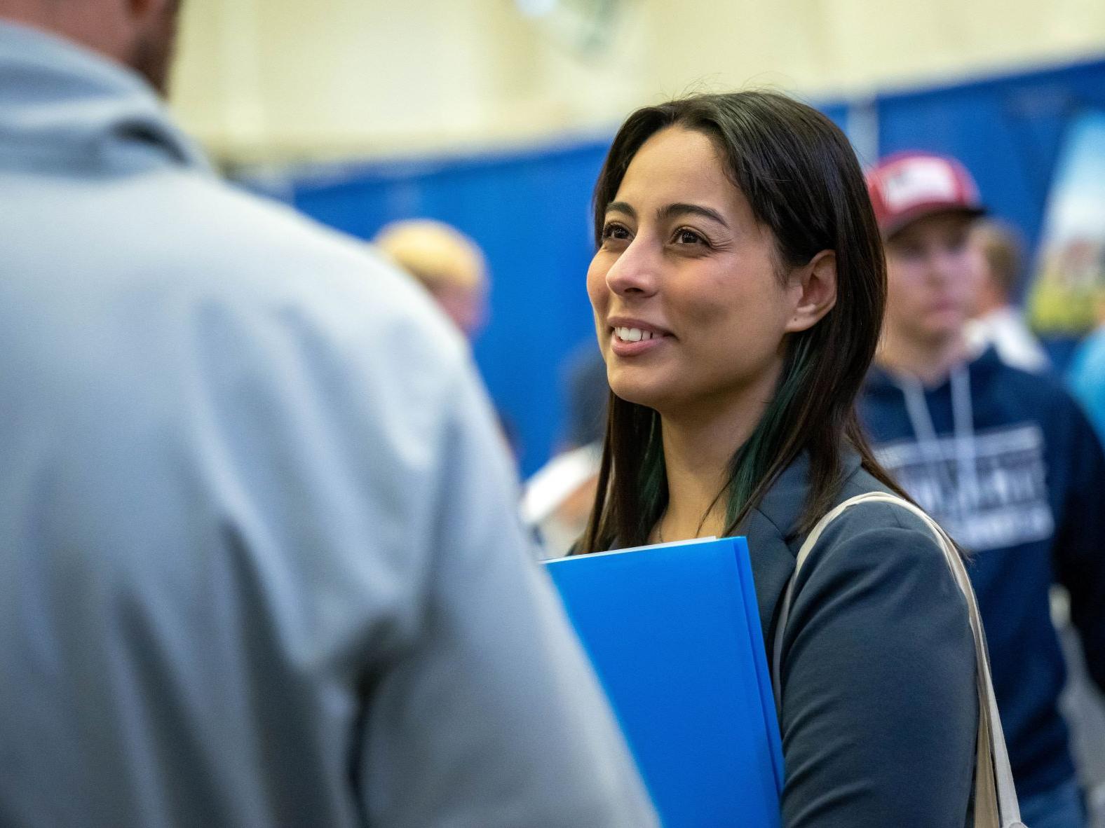 A female student talks with a recruiter at Penn State Behrend's fall career fair.