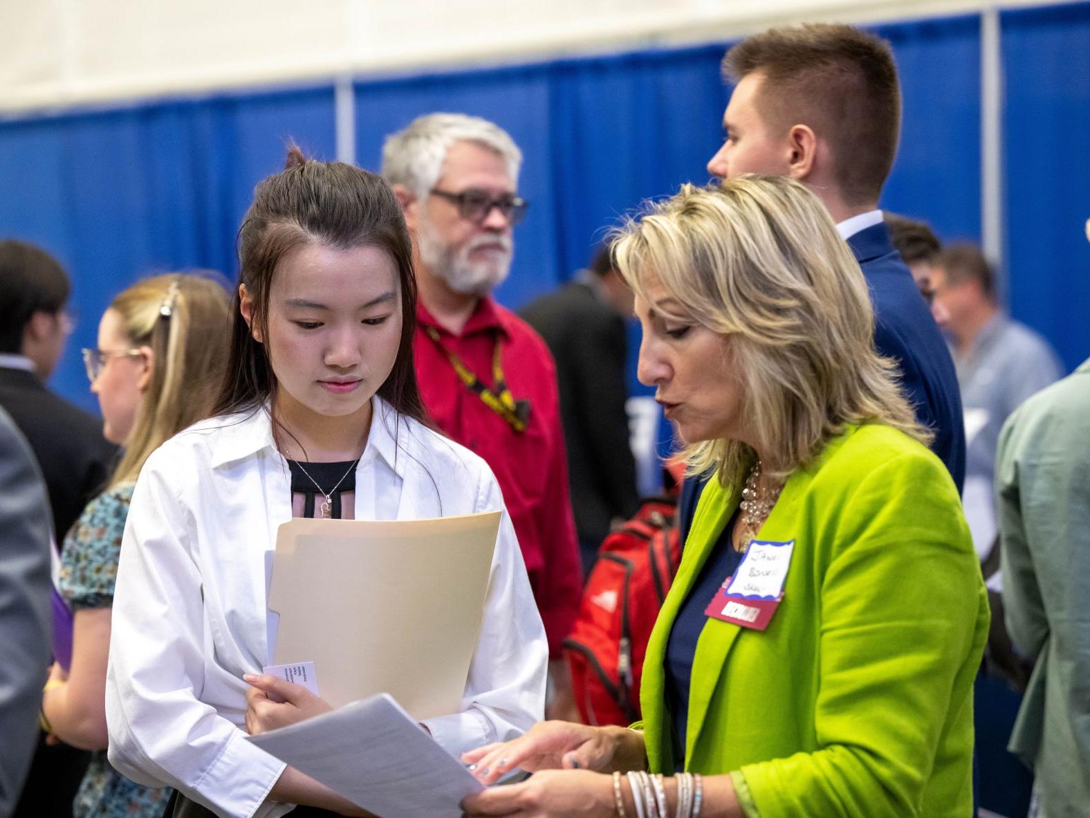 A female student talks with a corporate recruiter during Penn State Behrend's fall career fair.