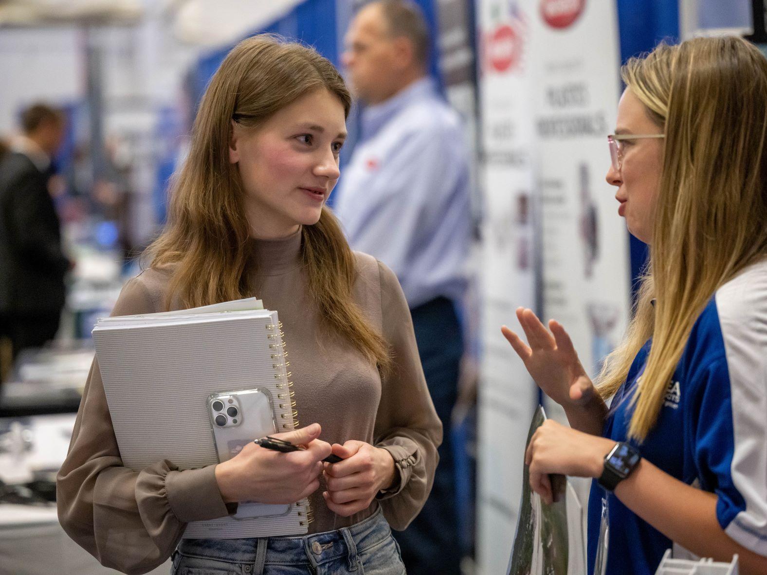 A female student talks with a corporate recruiter at Penn State Behrend's fall career fair.