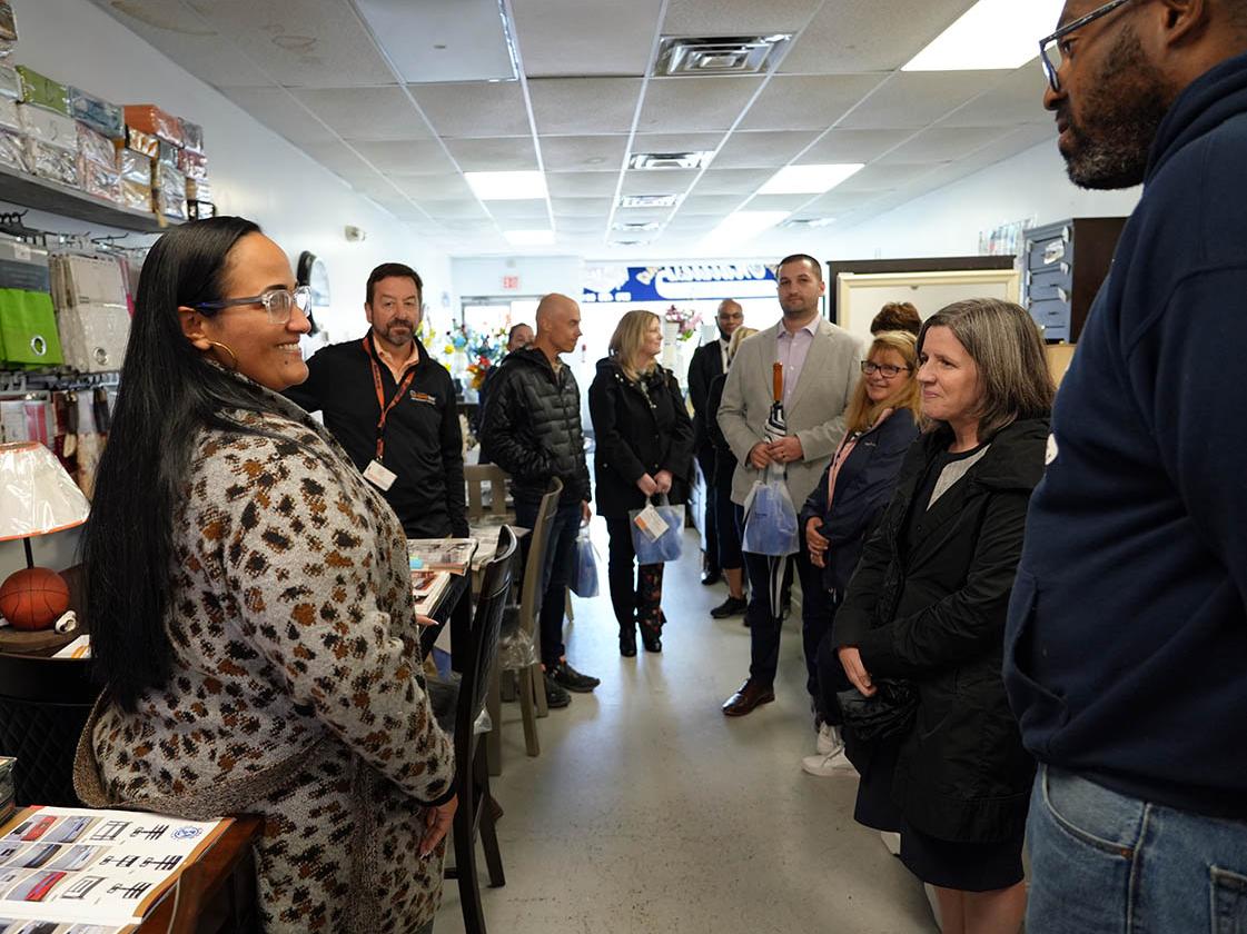 Group of people gathered inside a business speaking with its owner.