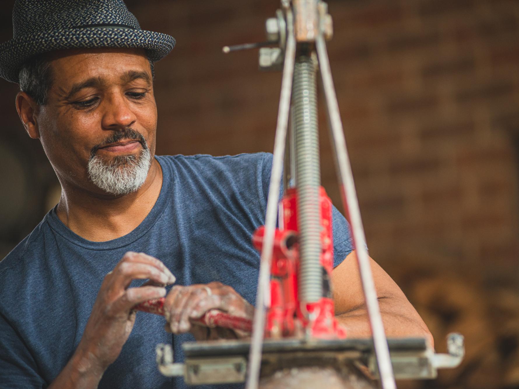  B Stephen Carpenter II, Michael J. and Aimee Rusinko Kakos Dean in the College of Arts and Architecture, works with his hands a tool for shaping objects out of clay