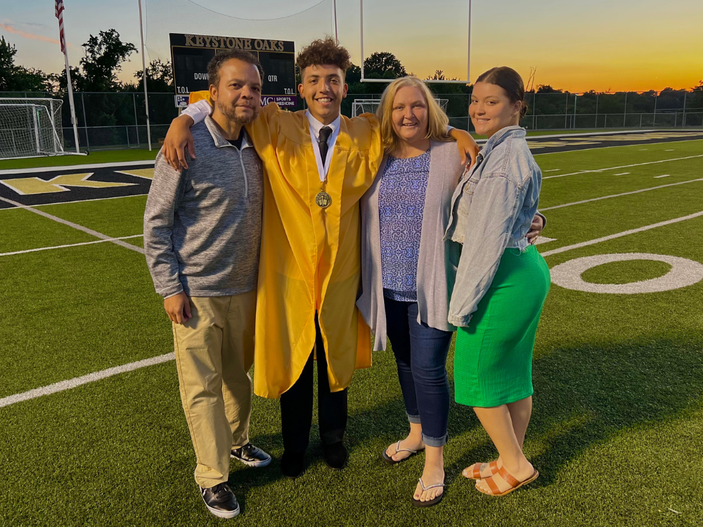 Haley Park (far right) stands with her father (far left), brother (second from left), and mother (second from right) on a football field at her brother's high school graduation