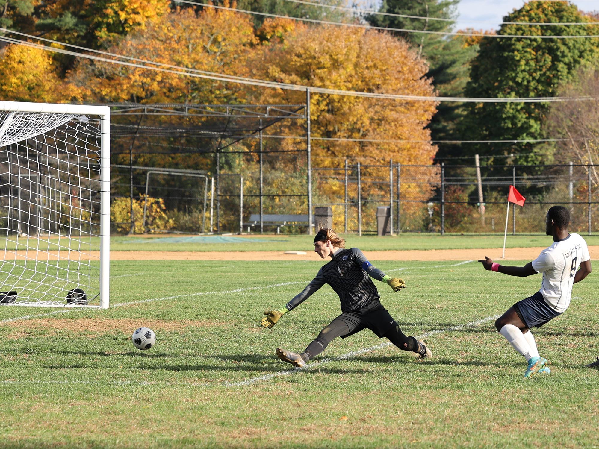 A Brandywine men's soccer player sends the ball past the opposing team's goalkeeper.