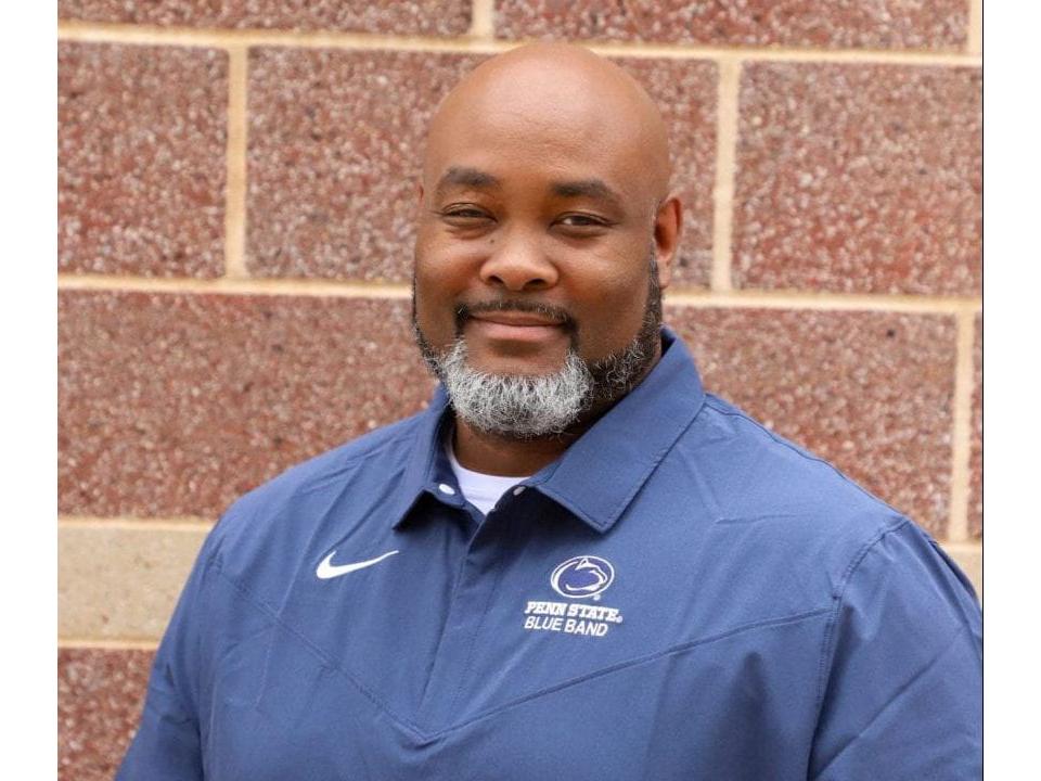 Portrait of Phillip Ealy wearing a blue Penn State Blue Band polo shirt.