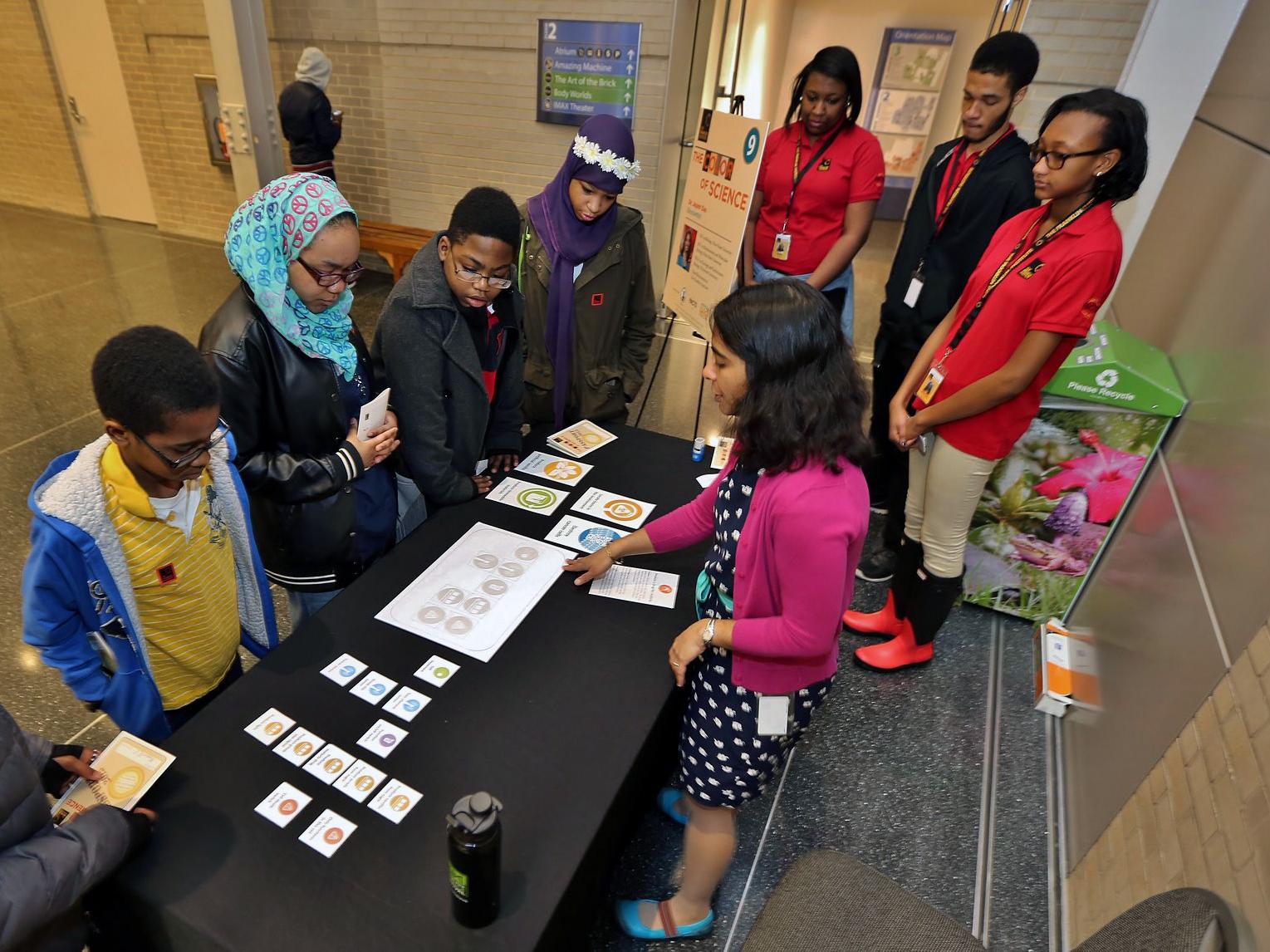Das interacts with kids at museum table