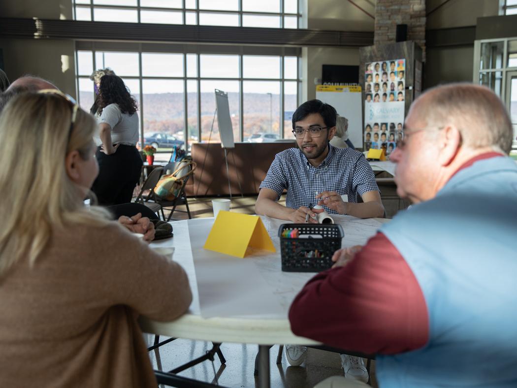 A Penn State landscape architecture student sits at a table with local residents during the community design charrette on Oct. 30.