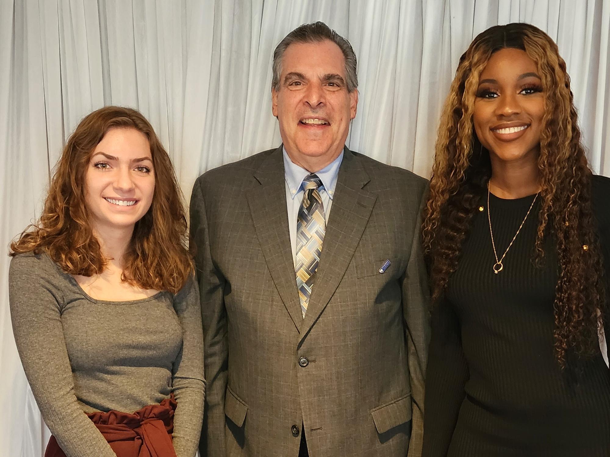 Three people standing together for a presentation.