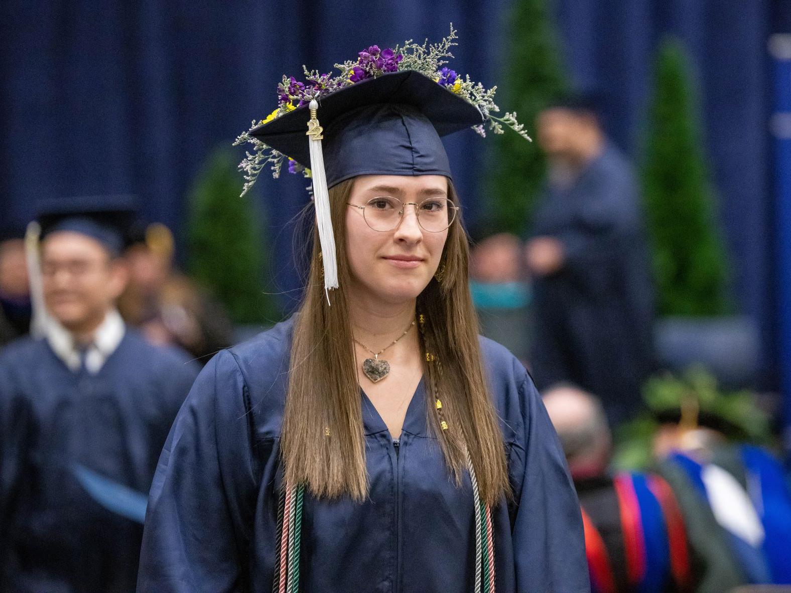 A new graduate walks back to her seat after receiving her degree at Penn State Behrend's fall 2022 commencement program.