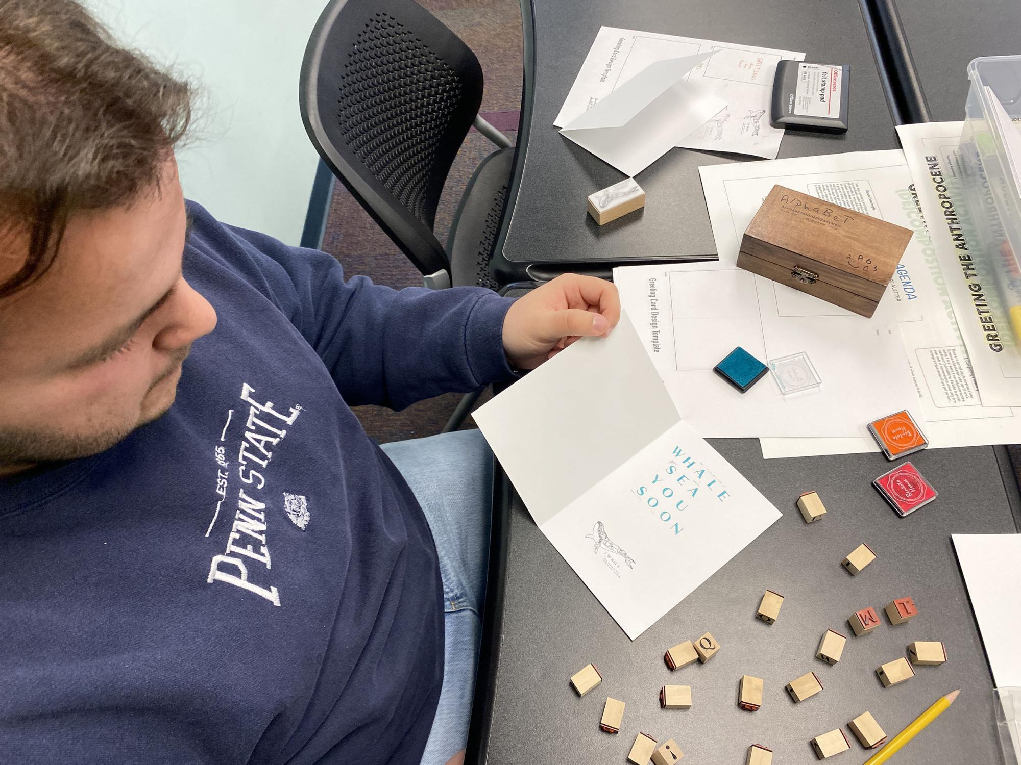Student Ryan Hall works on their greeting card at their desk as part of the Dec. 2 workshop.