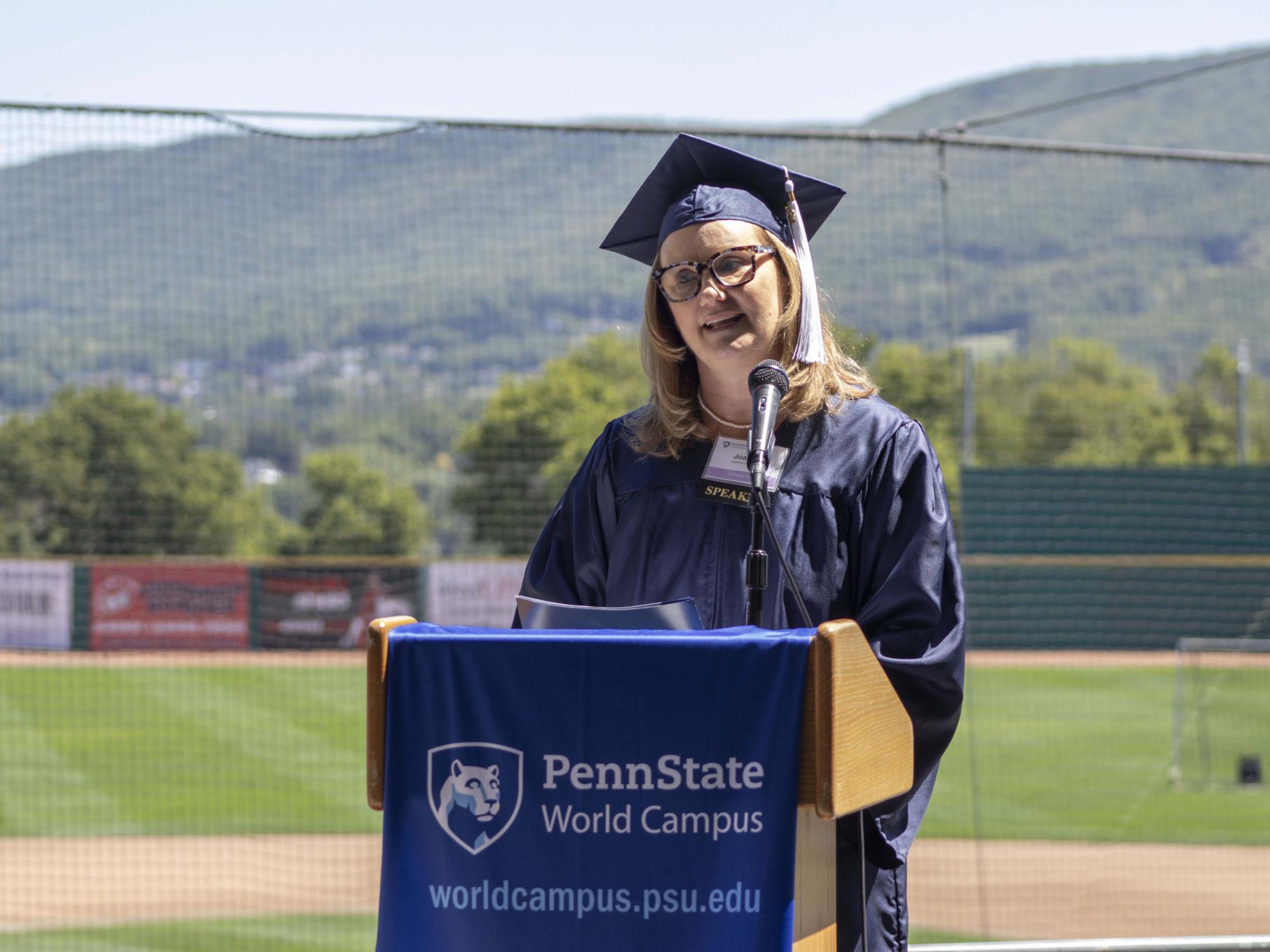 Joanne DeMarco speaks at a podium during a graduation celebration for Penn State World Campus.