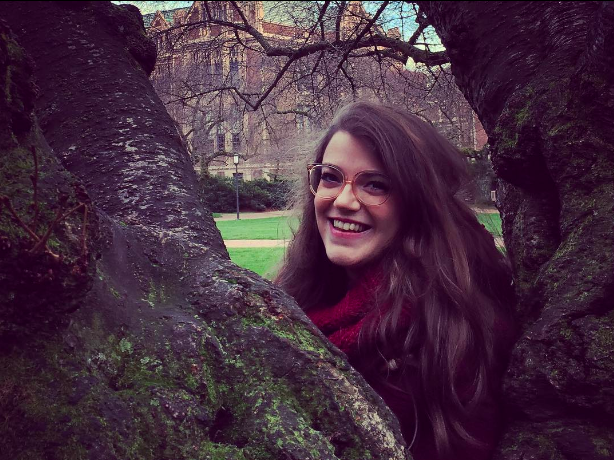 Michelle Funk poses for a photo sitting between two branches of a tree