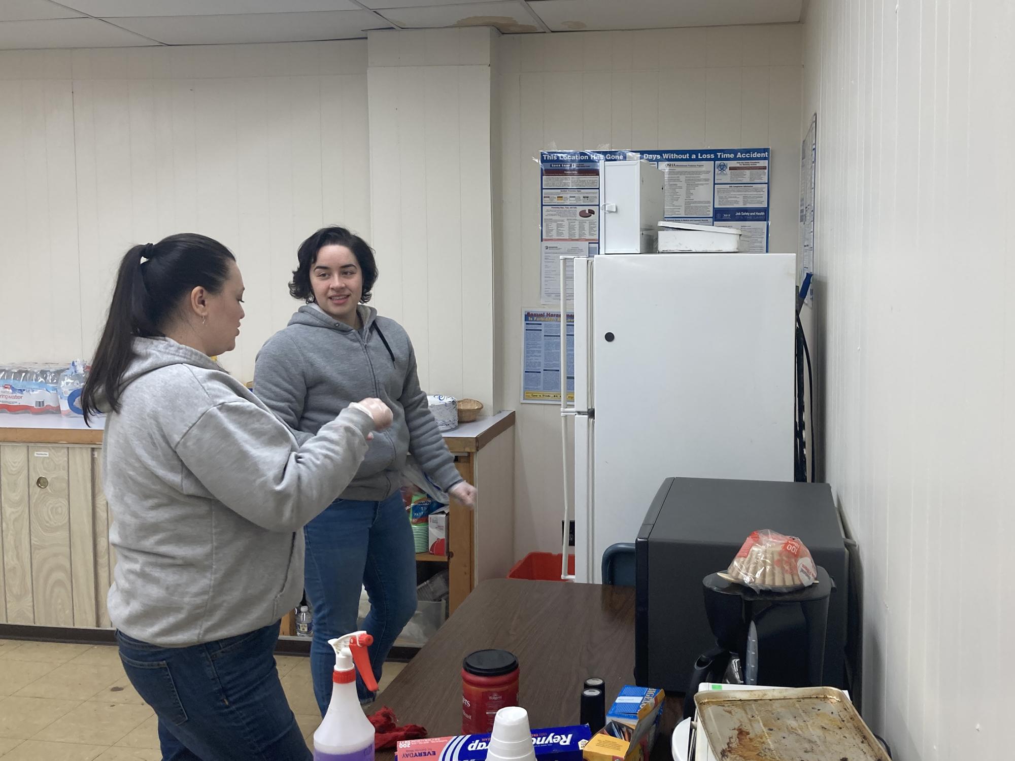 Two people clean a kitchen.