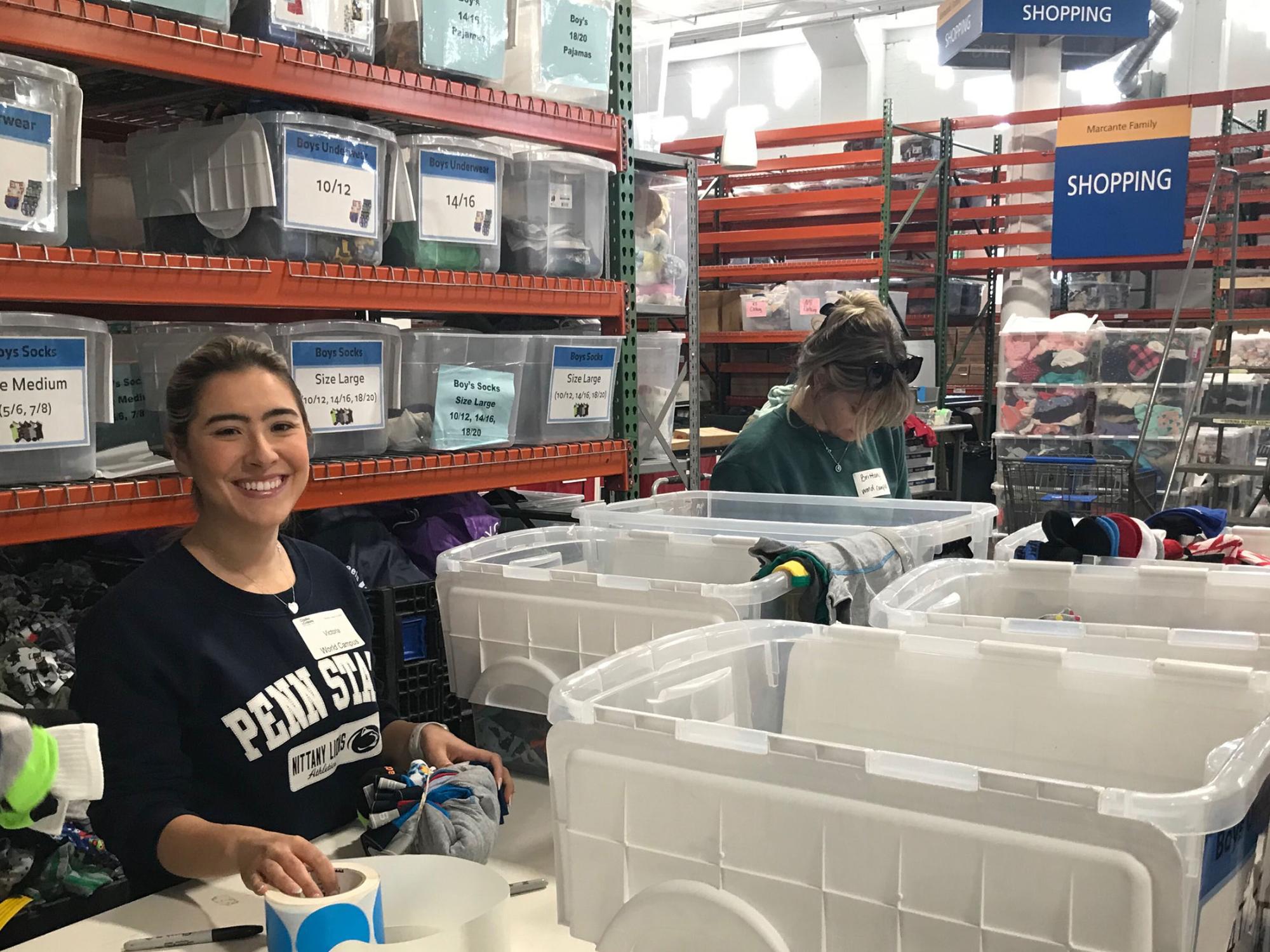 Two people sort items into containers in a warehouse.