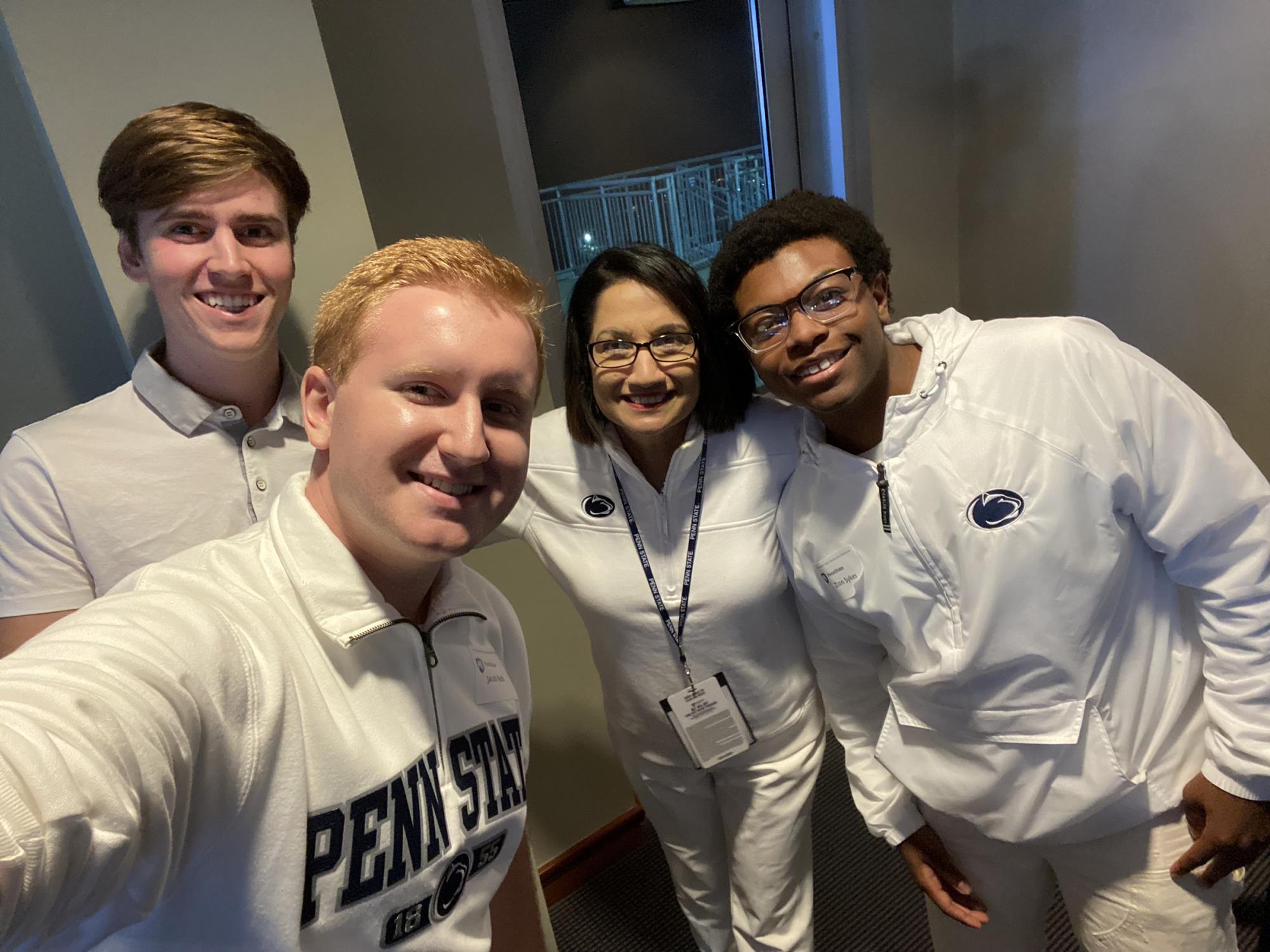 Jacob Roth (front) takes a selfie with Joshua Ross (back left), Penn State President Neeli Bendapudi (back center) and Zion Sykes (back right).