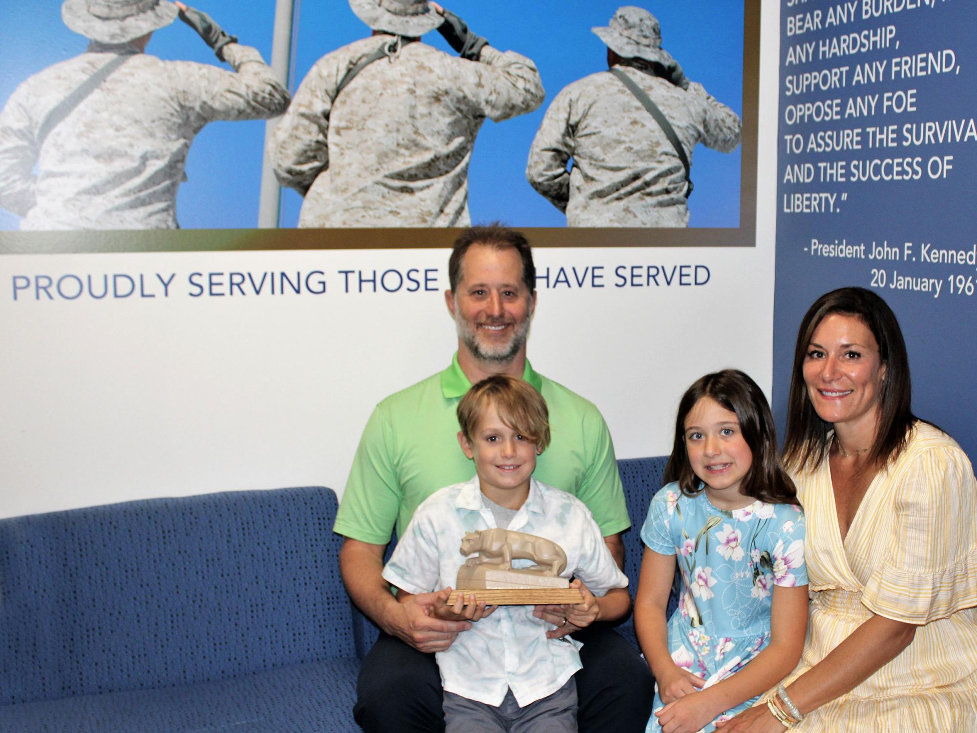 campus donors E.J. and Aryn Long, sit on a sofa in the new Penn State Scranton Veterans Lounge with their children, Addison and Parker