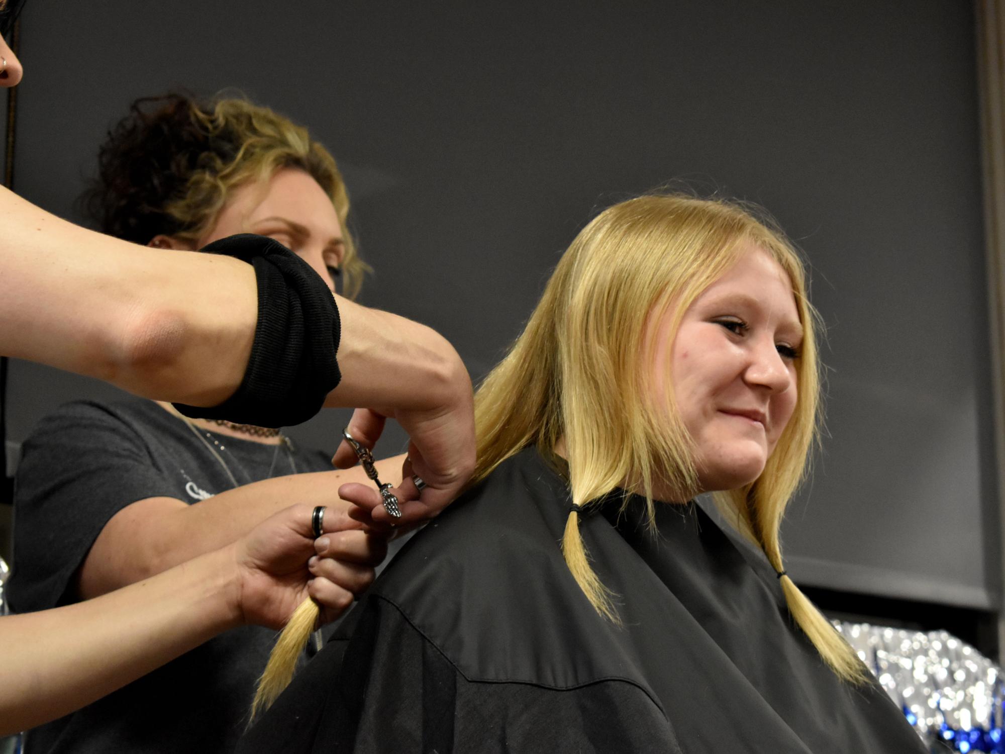 Abby Freemer has her hair cut after donations reach her goal during the THON hair auction