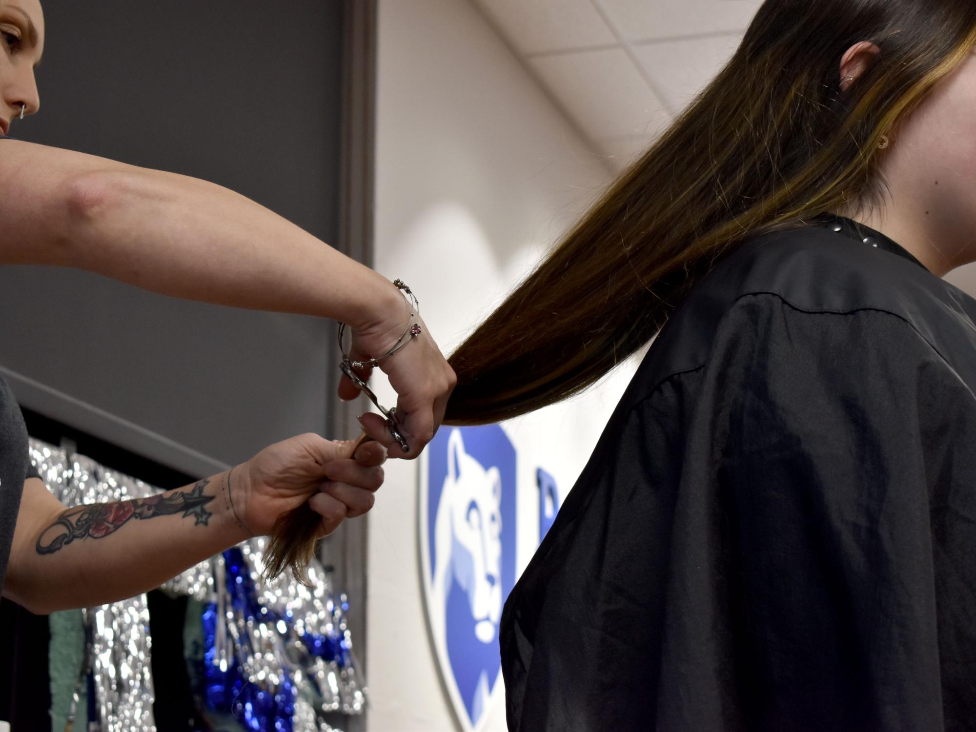 Louise Bennett has her hair cut from behind during the THON hair auction