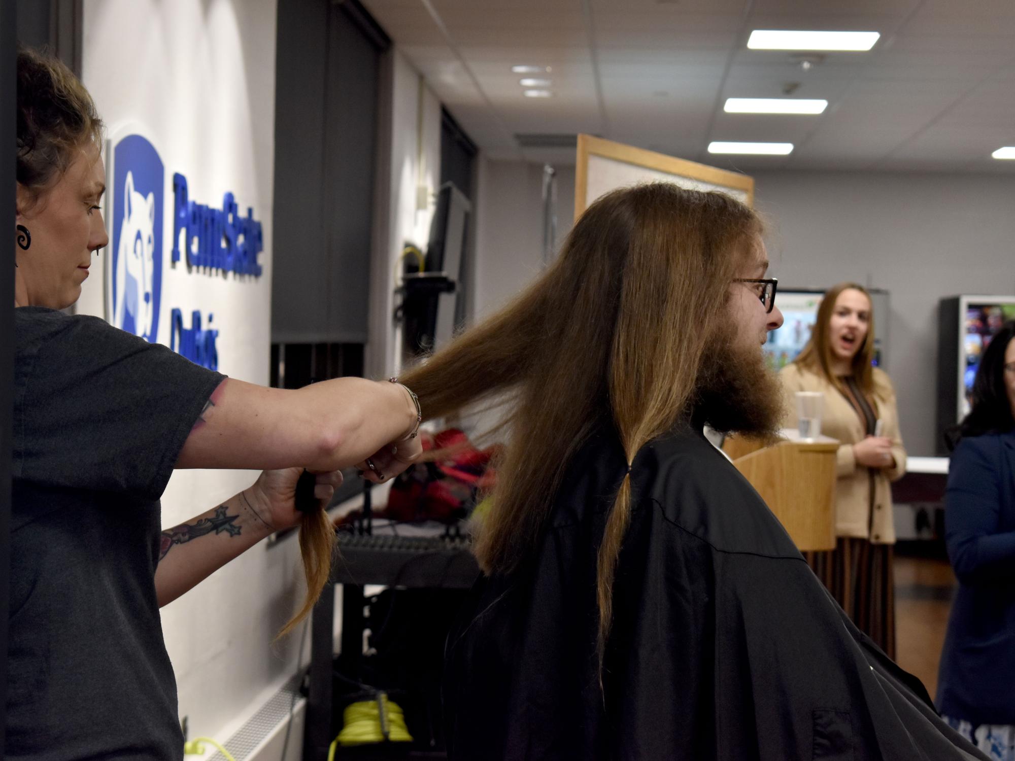 Josh Rishel's hair is cut during the THON hair auction after his donation goal was met