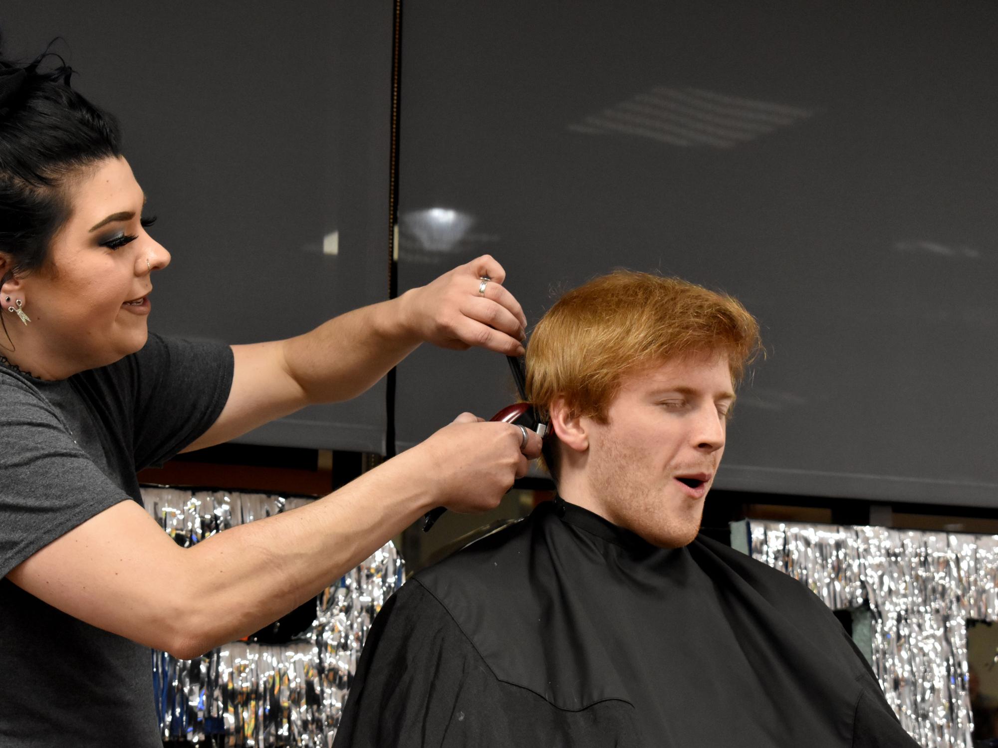 Eamon Jamieson feels the clippers for the first time as his head gets buzzed during the THON hair auction
