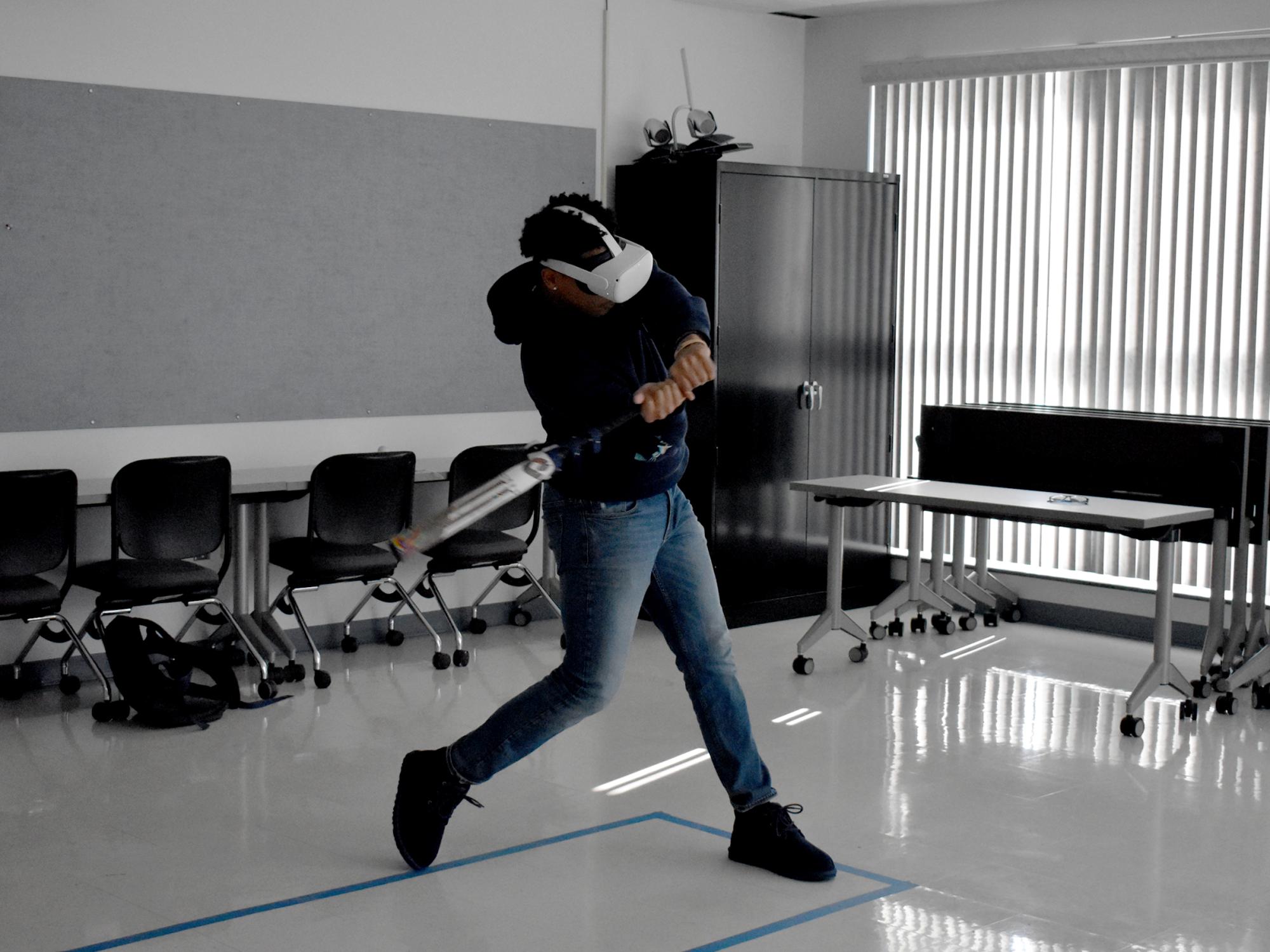 A baseball player from Penn State DuBois uses virtual reality equipment to practice hitting inside the DEF Building on campus