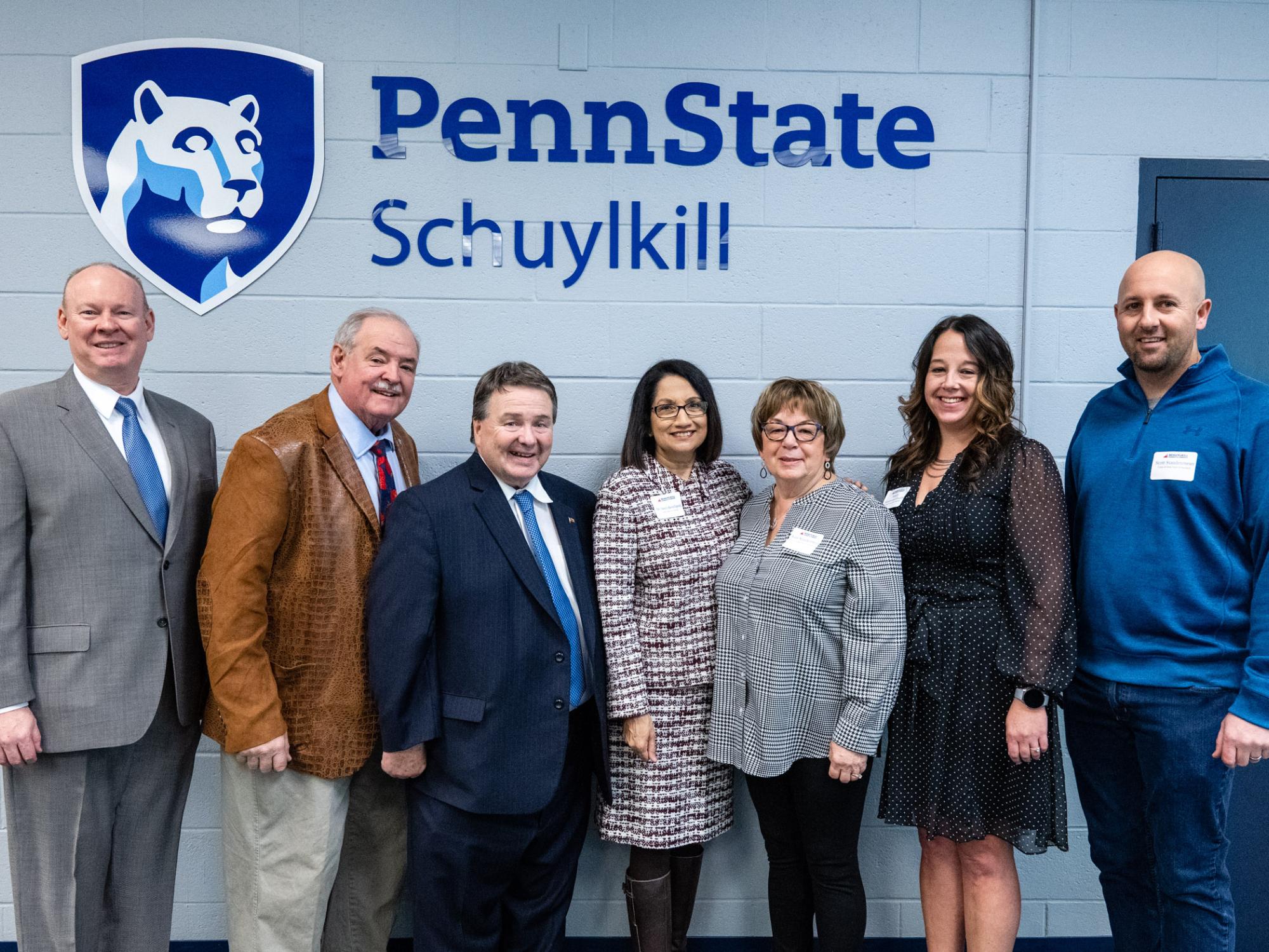 Attendees from the Schuylkill Chamber Business Executive Forum pose in front of a Penn State logo