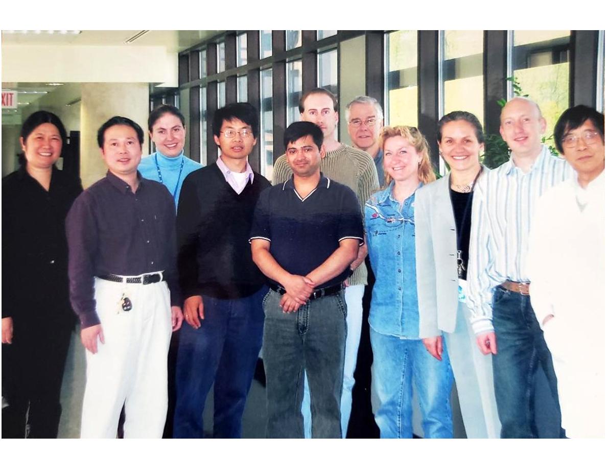 Joanna Floros stands with eleven of her collaborators in the Biomedical Research Building at Penn State College of Medicine. 
