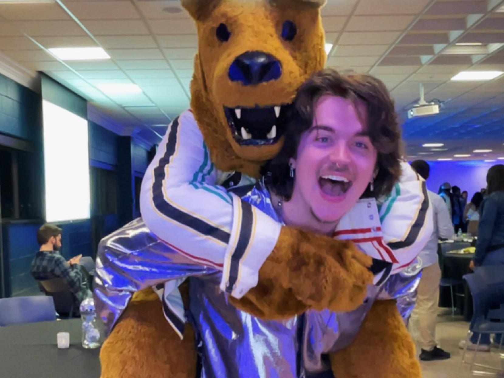 Photo of Max Kelly, carrying the Nittany Lion mascot on his back