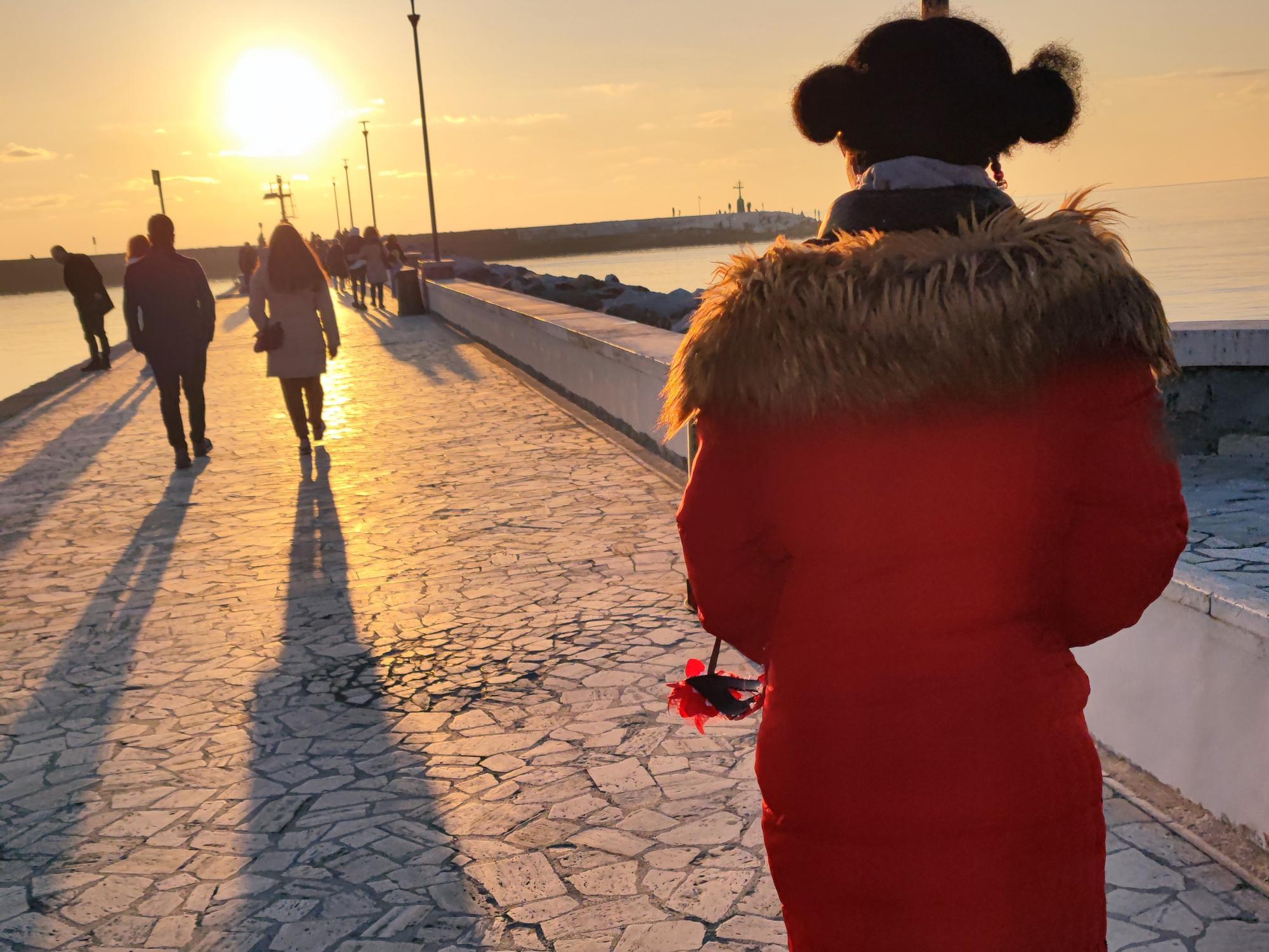 An image of a young woman on an Italian bridge at sunset