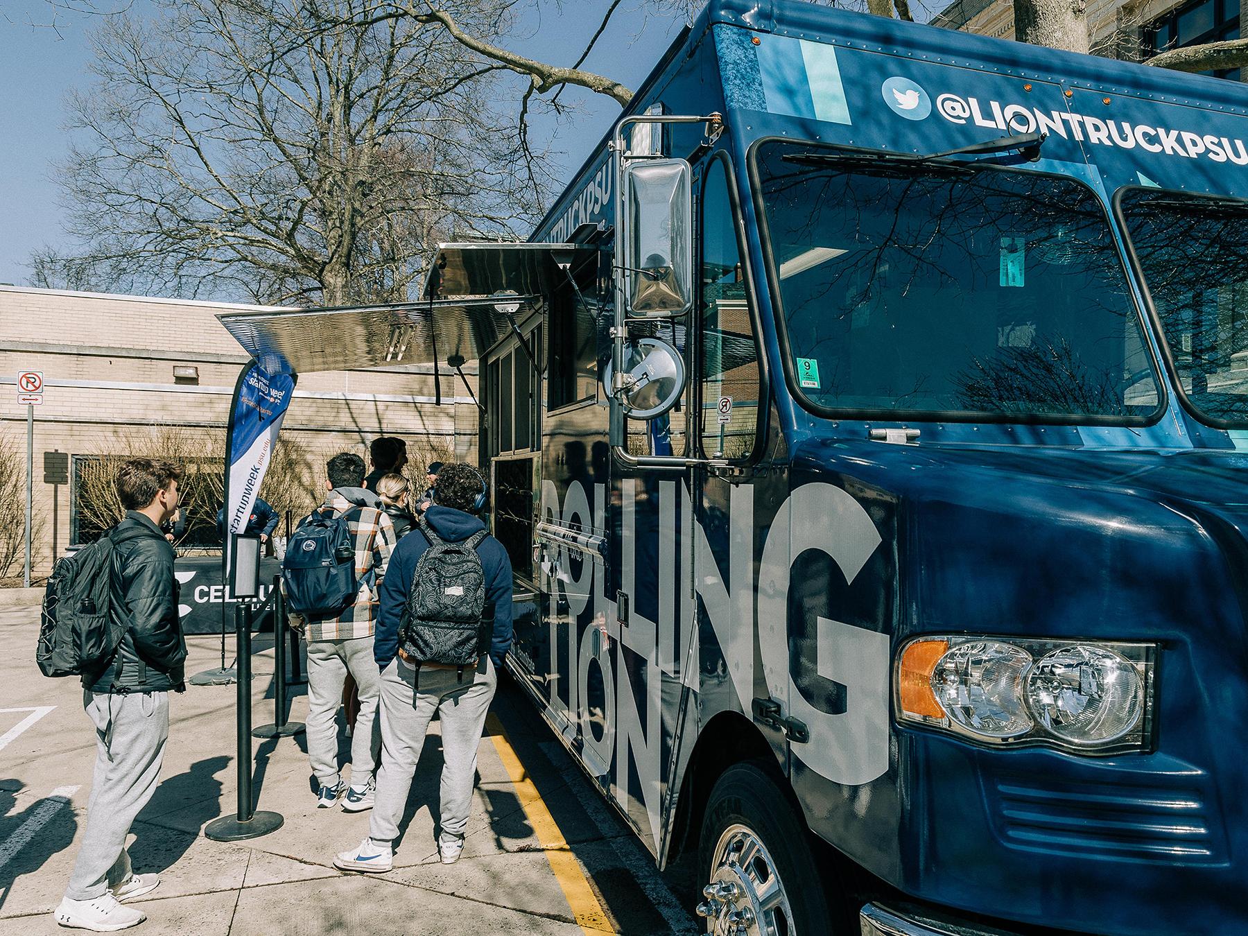 Students standing next to food truck