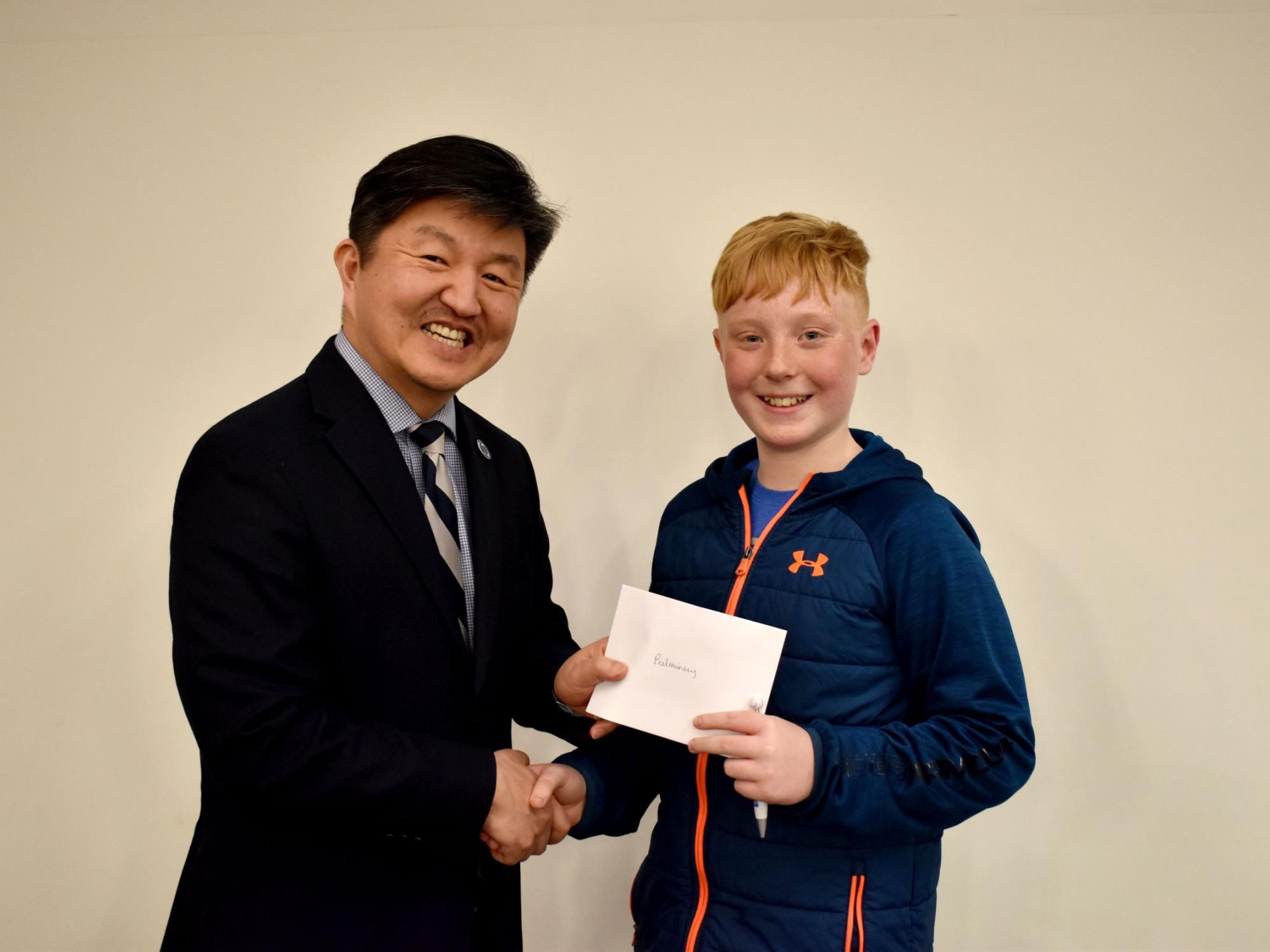 Kai Caskey of Saint Marys, right, receives the individual award for the preliminary round from Jungwoo Ryoo, chancellor and chief academic officer of Penn State DuBois