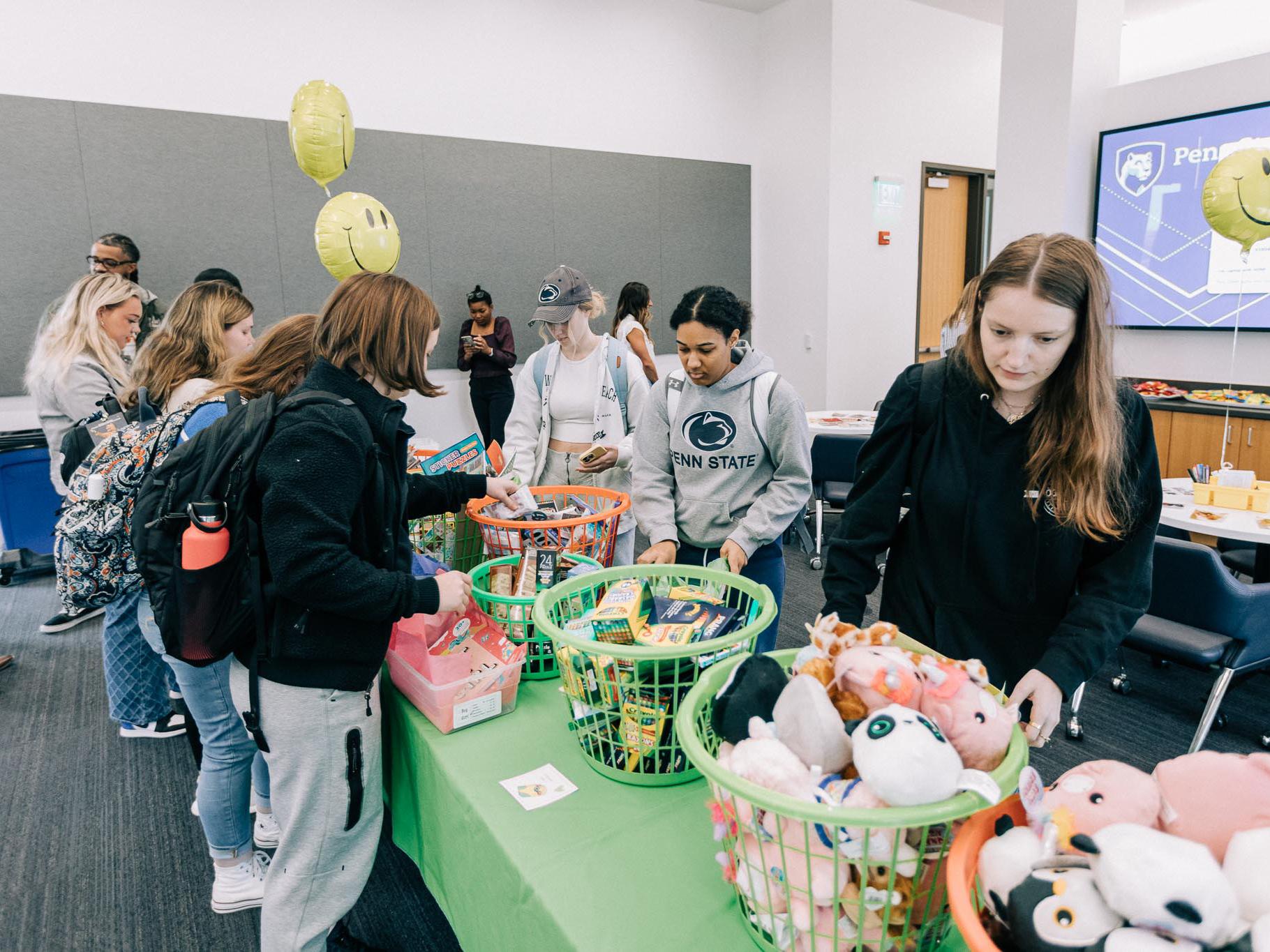Students grabbing toys from a table