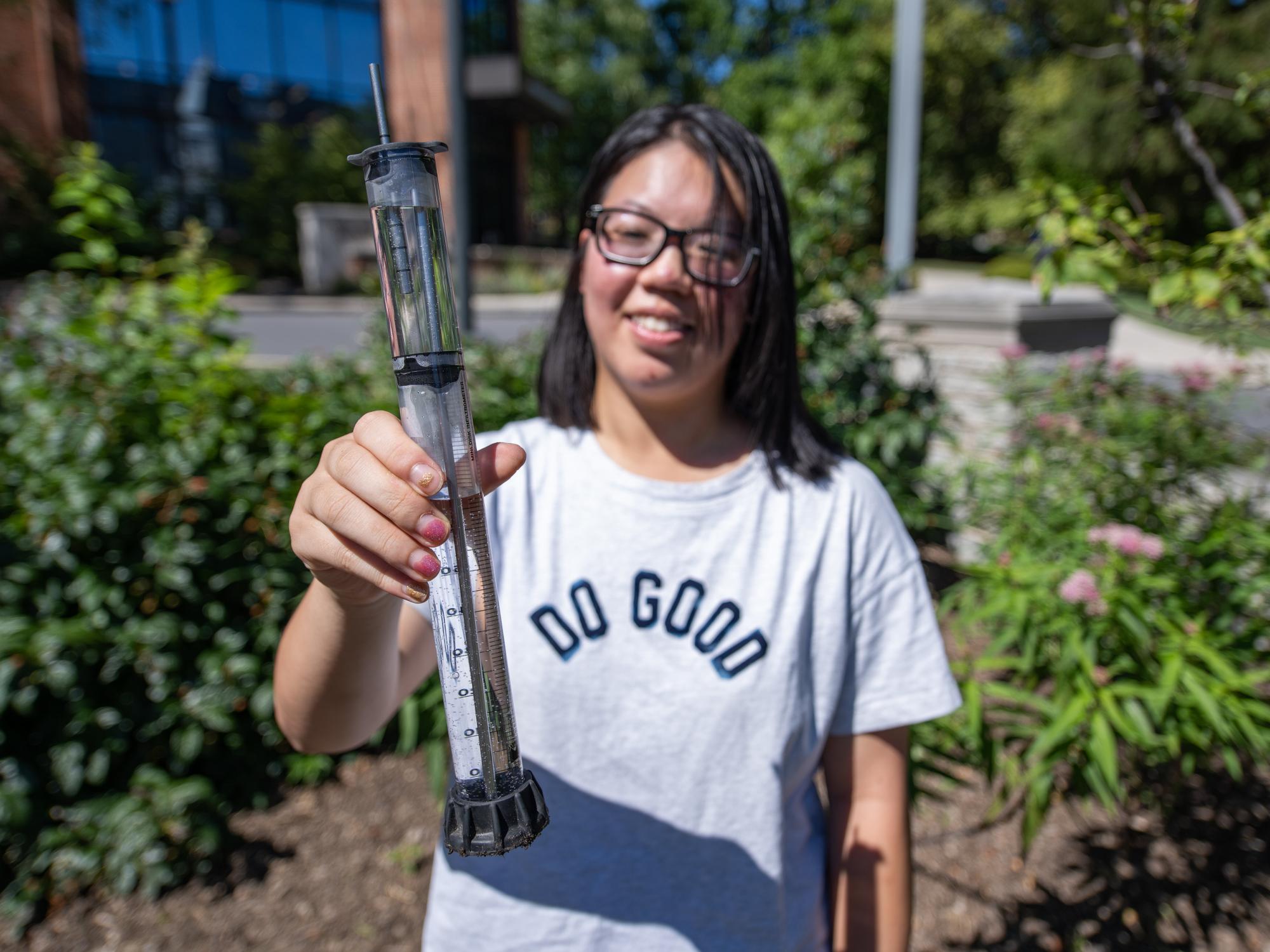 Student holds liquid sample