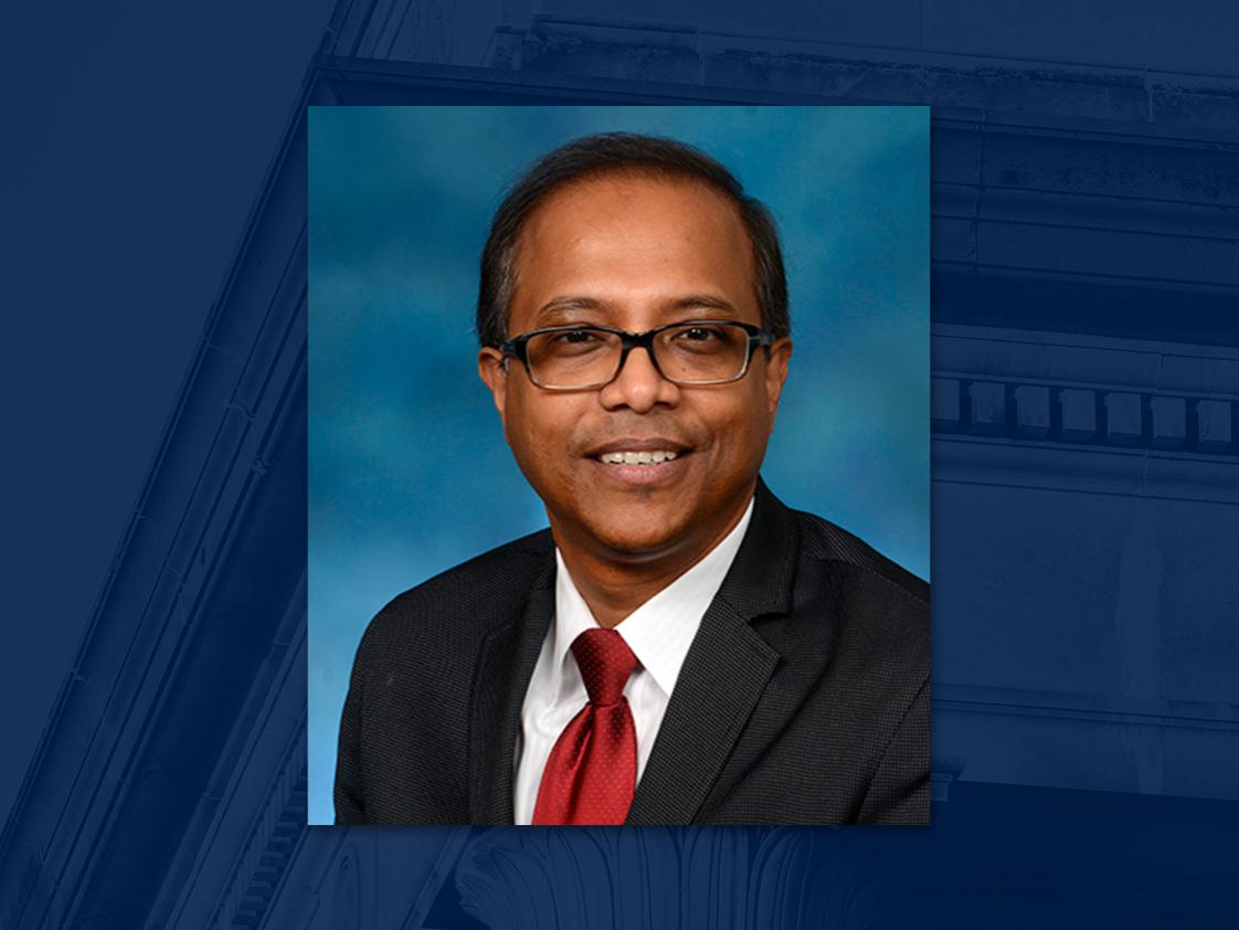 portrait style photo of professor with glasses smiling