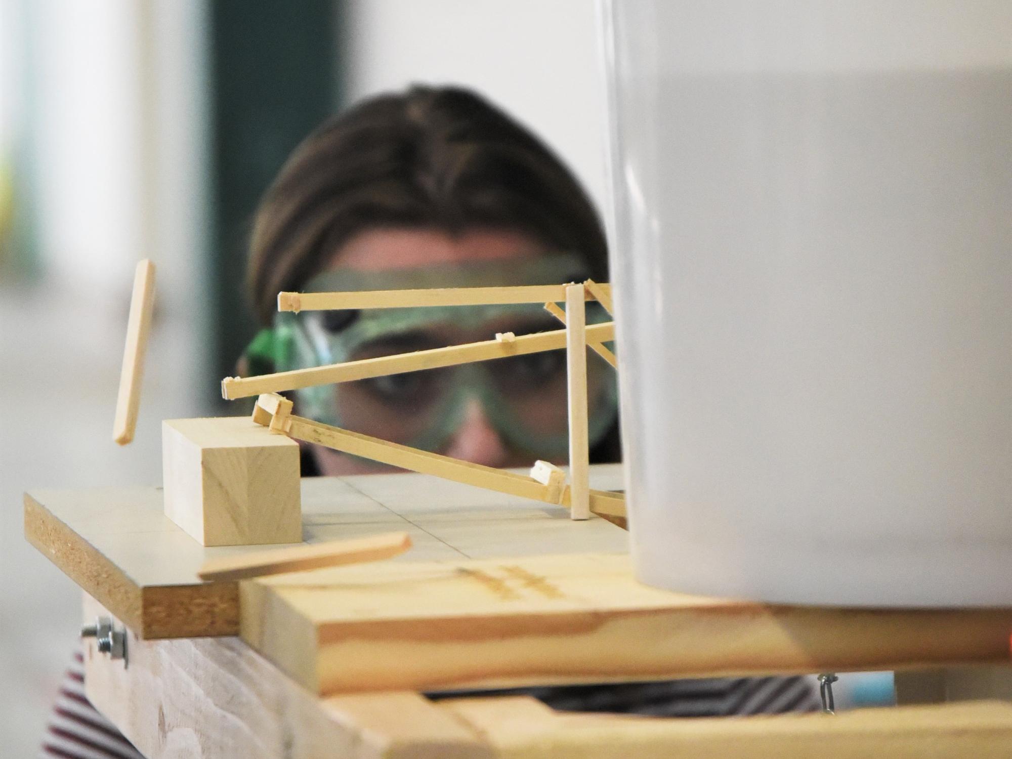A piece of wood pops off a model bridge during the Science Olympiad at Penn State Behrend.