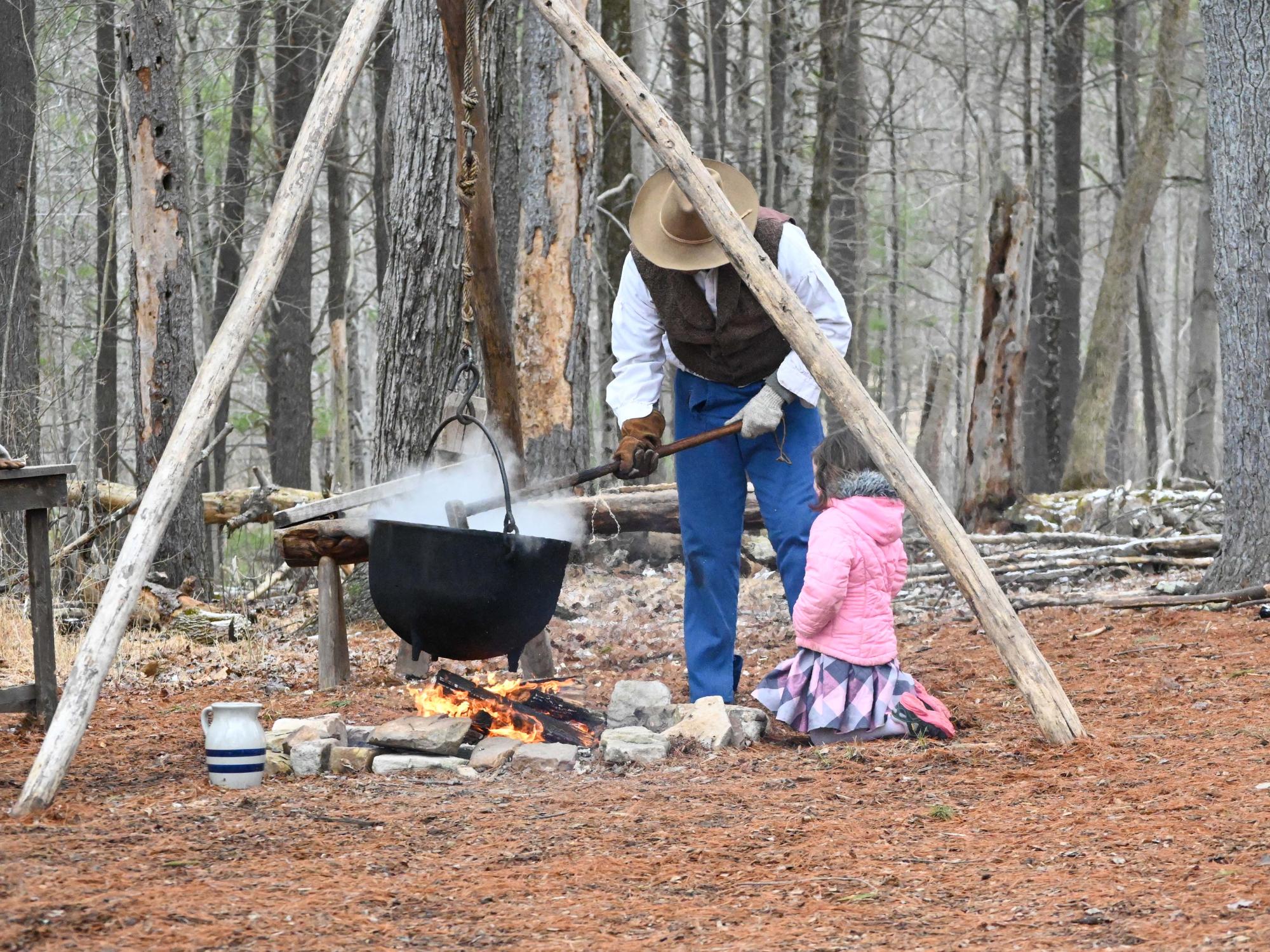Costumed interpreter demonstrates boiling maple sap