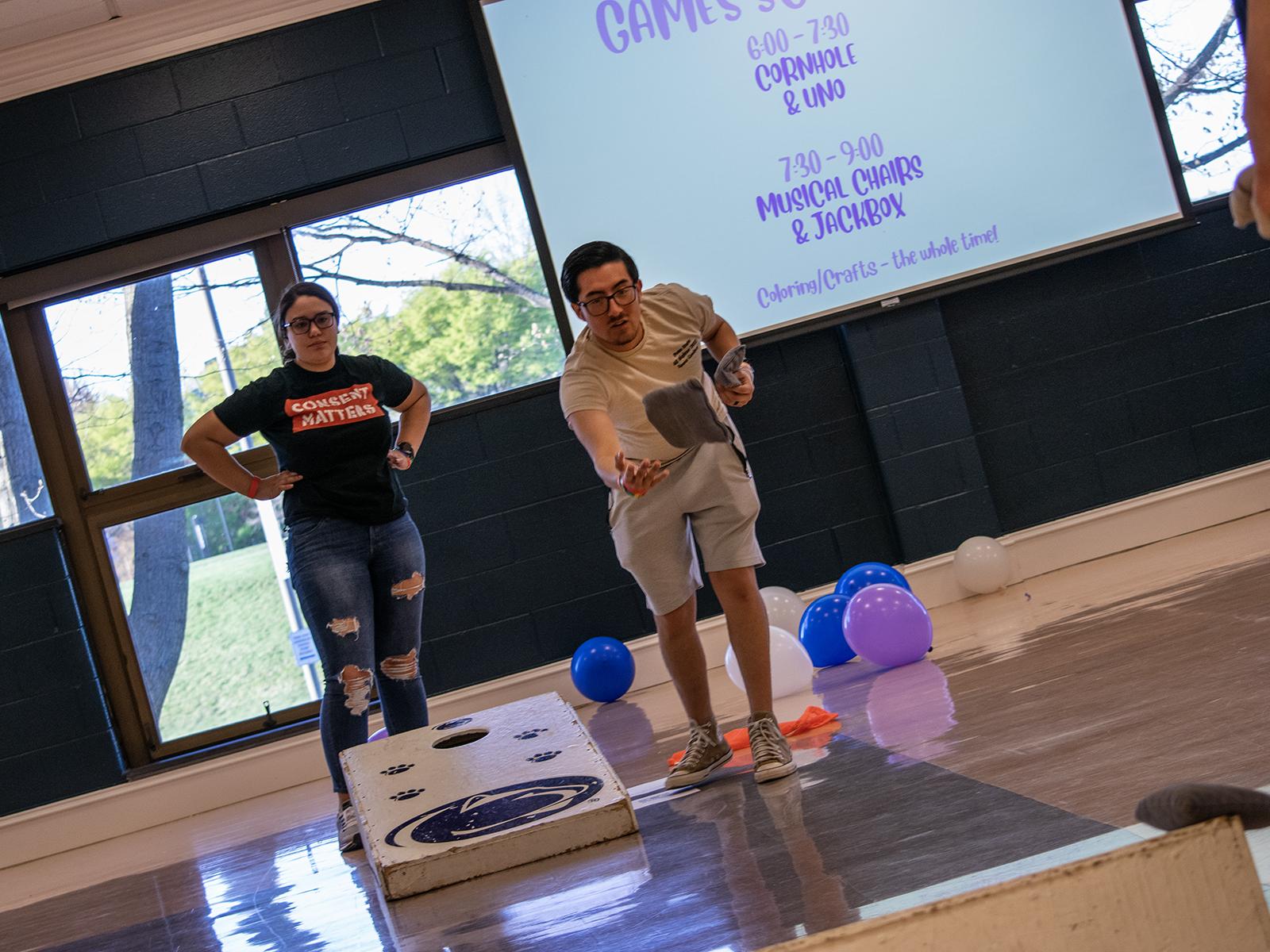 Photo of two students playing cornhole during a game night fundraiser held in the Capital Union Building at Penn State Harrisburg
