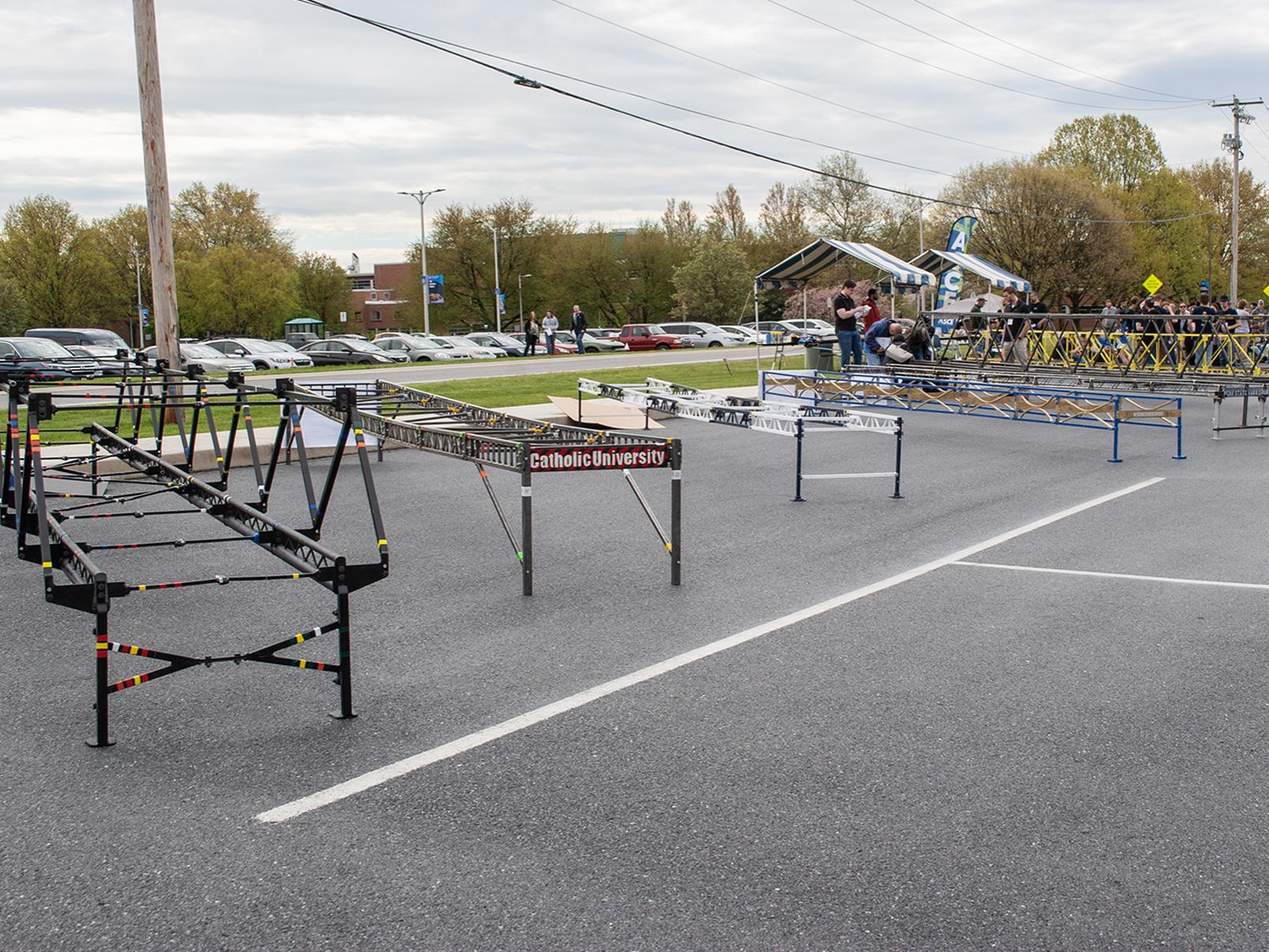 Steel bridges lined up in a  Penn State Harrisburg parking lot for a competition