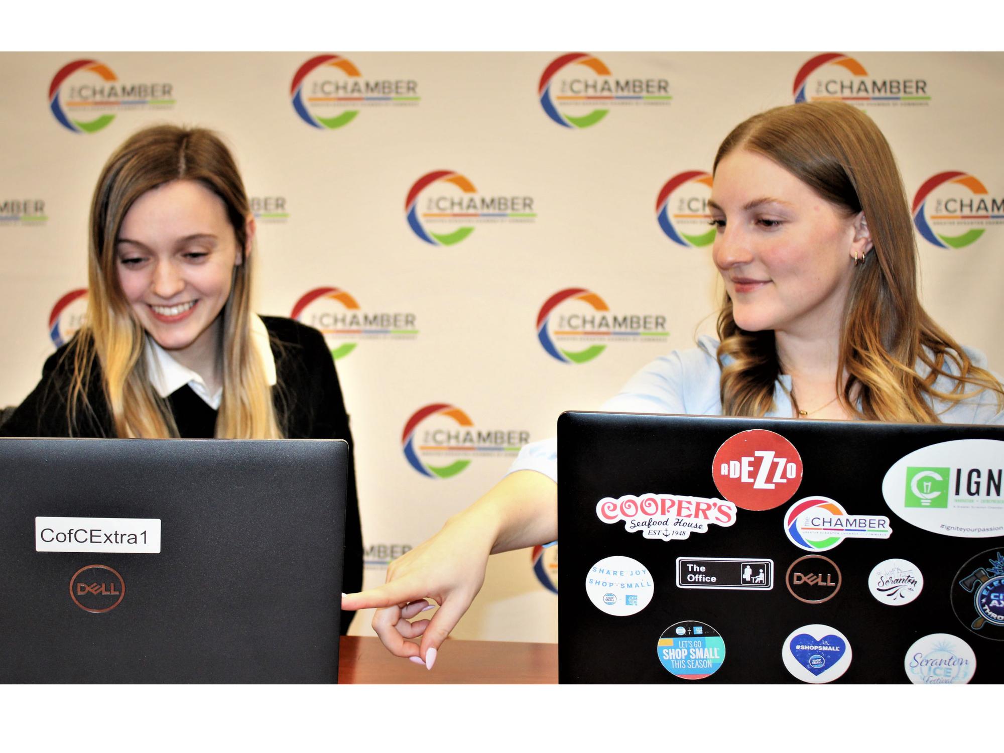 Burdick and Miller sitting together at the Chamber office with their laptops, ready to work