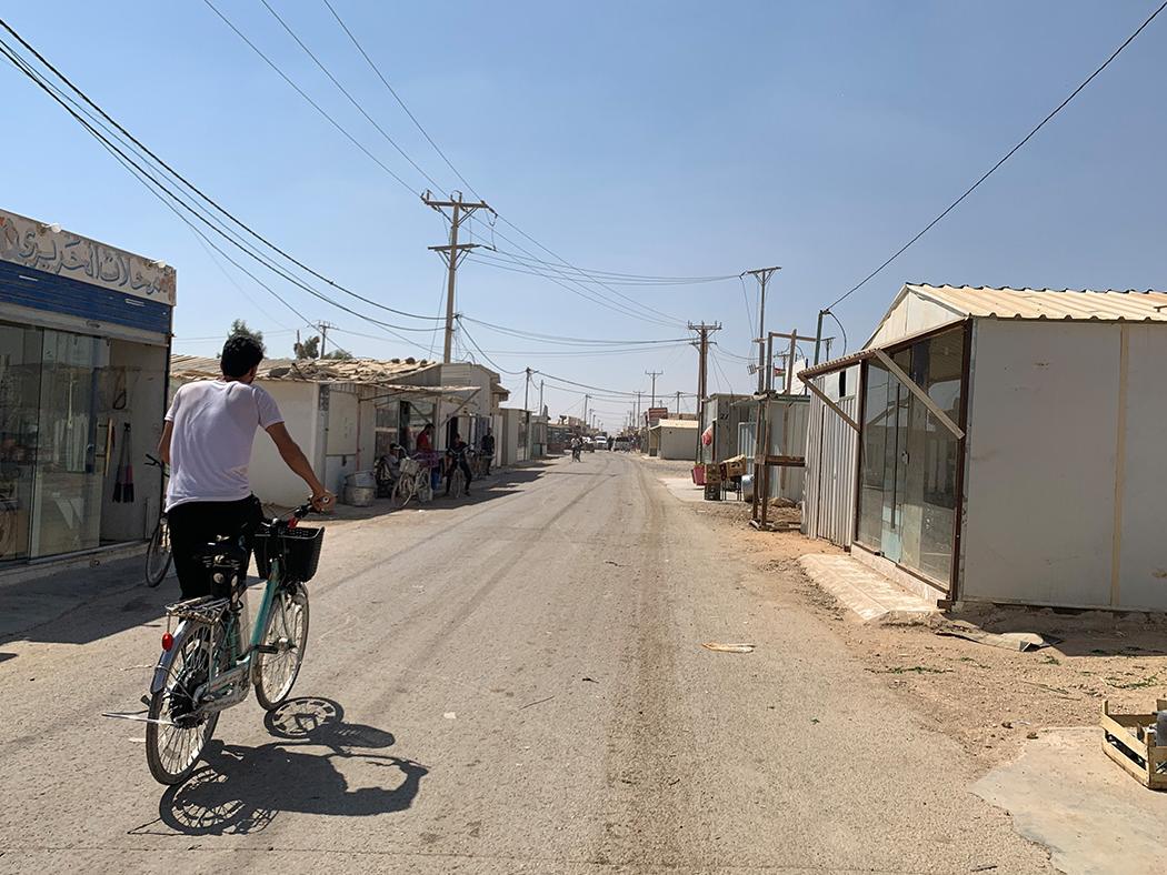A man on a bicycle drives through the Zaatari camp in Jordan.