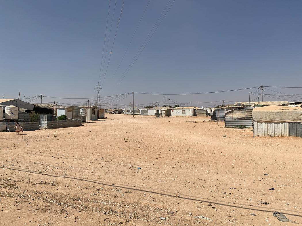 A view of the Zaatari camp in Jordan featuring small dwellings on a flat, dirt surface.