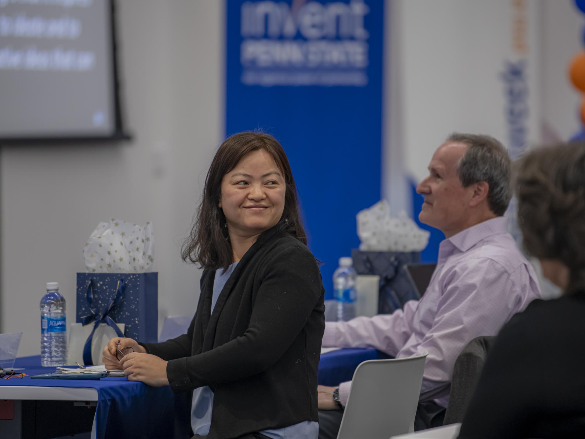 A woman sitting in a chair smiles