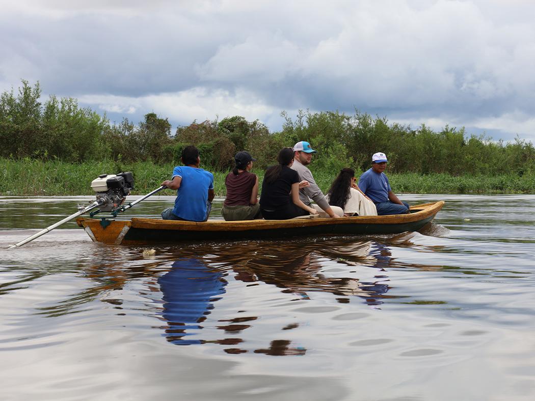Penn State students on a boat with a guide in the Clarevito community within Peru. 