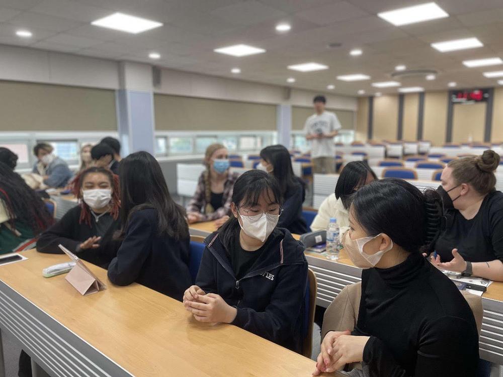 KOR 499 students sitting in desks having conversations with students from the Daewon Foreign Language High School. 