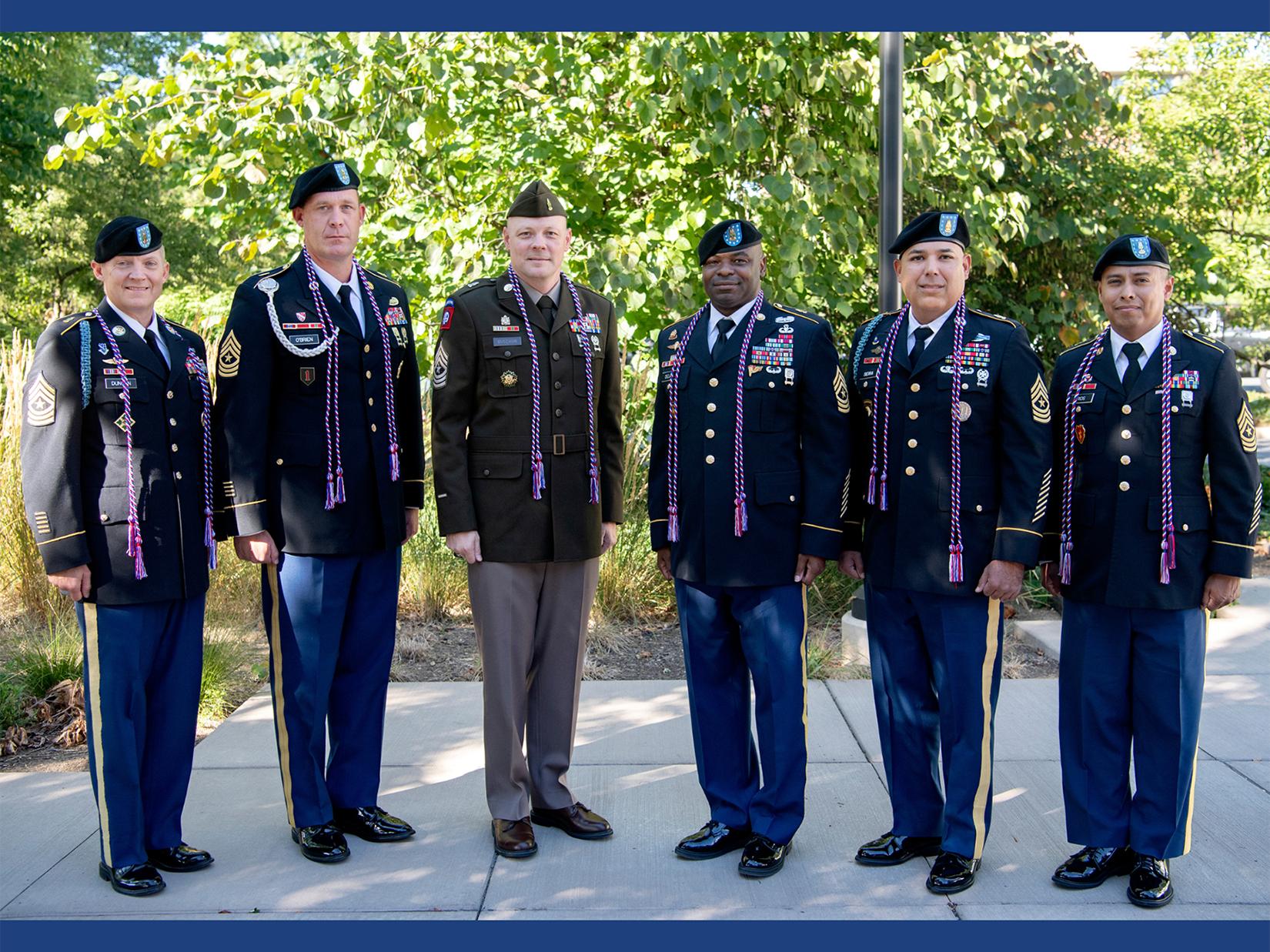 Six men stand in military dress uniforms.
