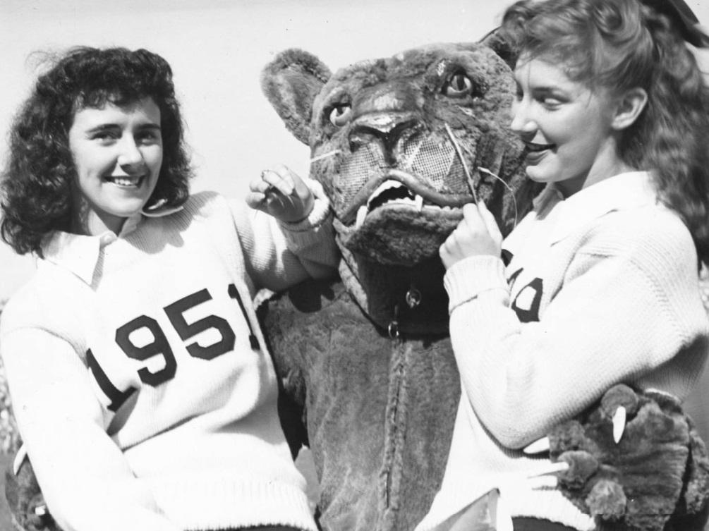The Nittany Lion poses with two female cheerleaders in 1951.