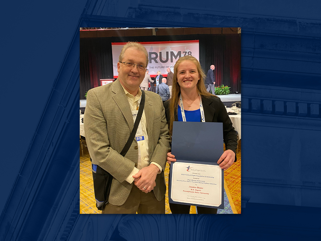 Man with glasses poses next to young woman holding certificate at business gathering.