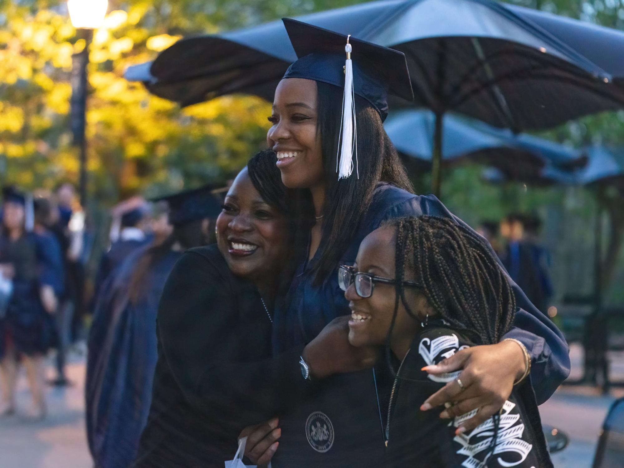 Female graduate holding loved ones during a photo.