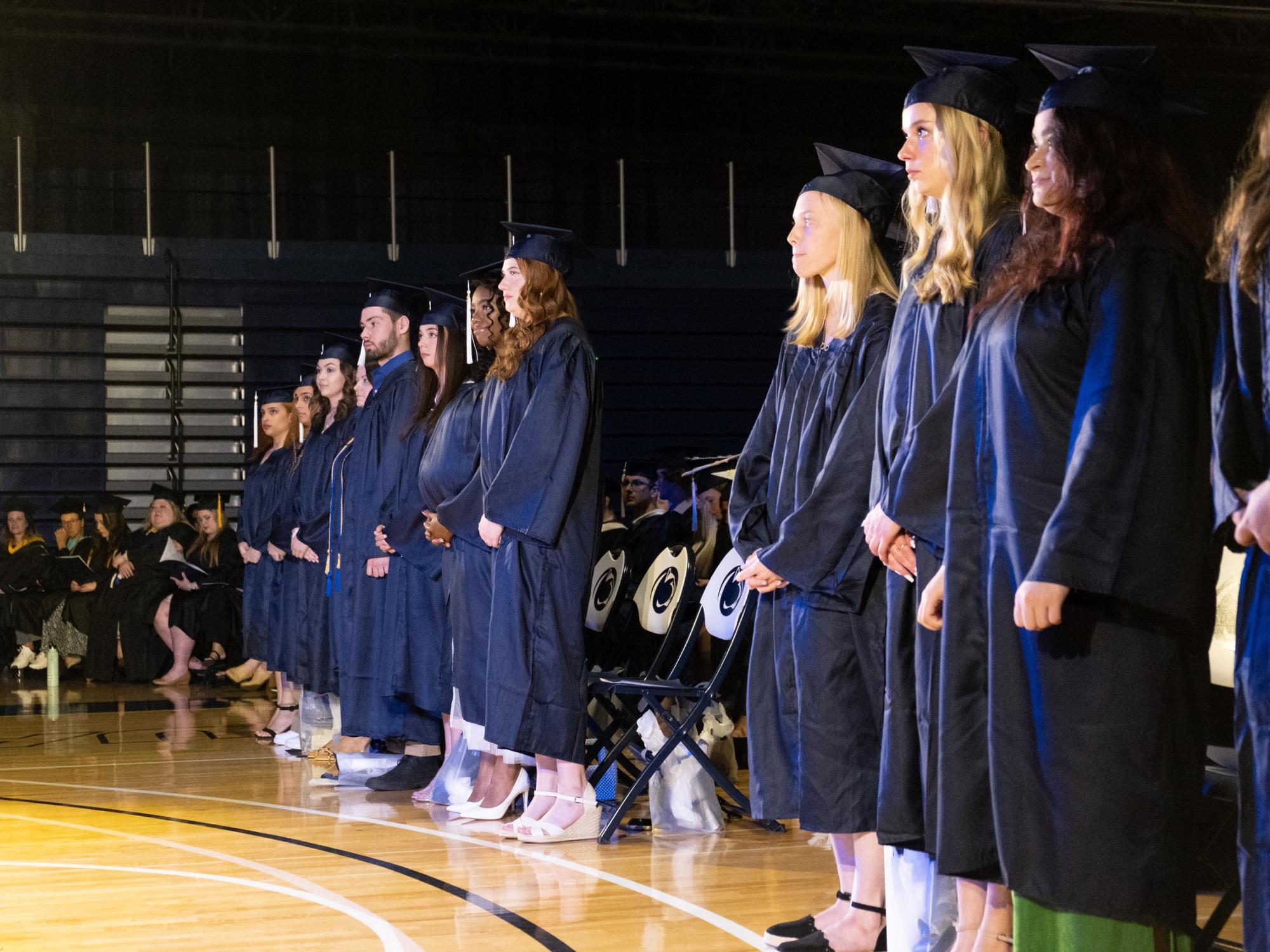 A line of students in graduation caps and gowns.